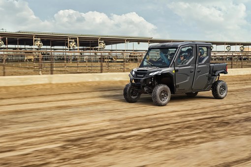 Three-quarter front angle of a person driving a side x side off-road. opens in a new window