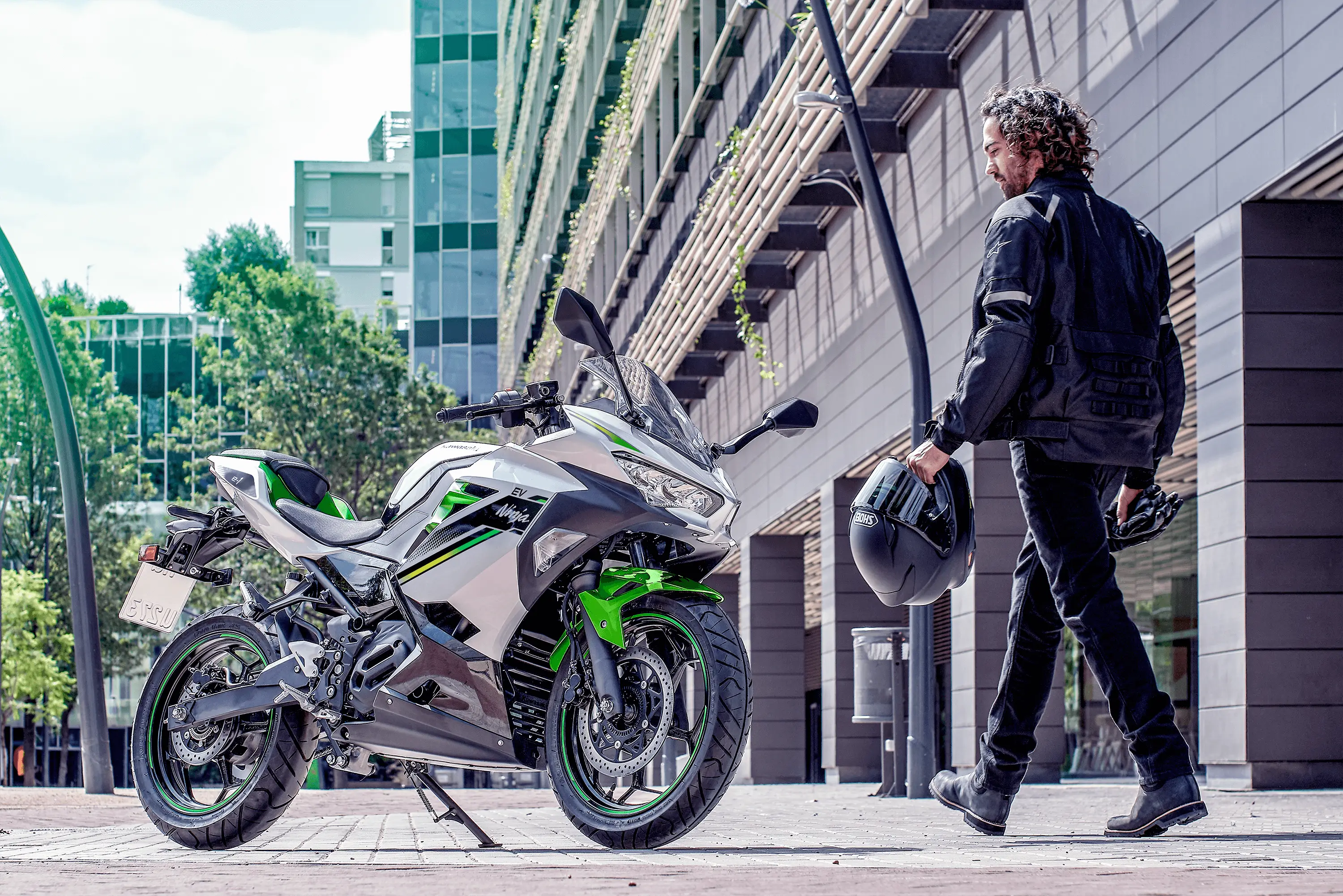 Back angle of a person approaching a parked motorcycle.