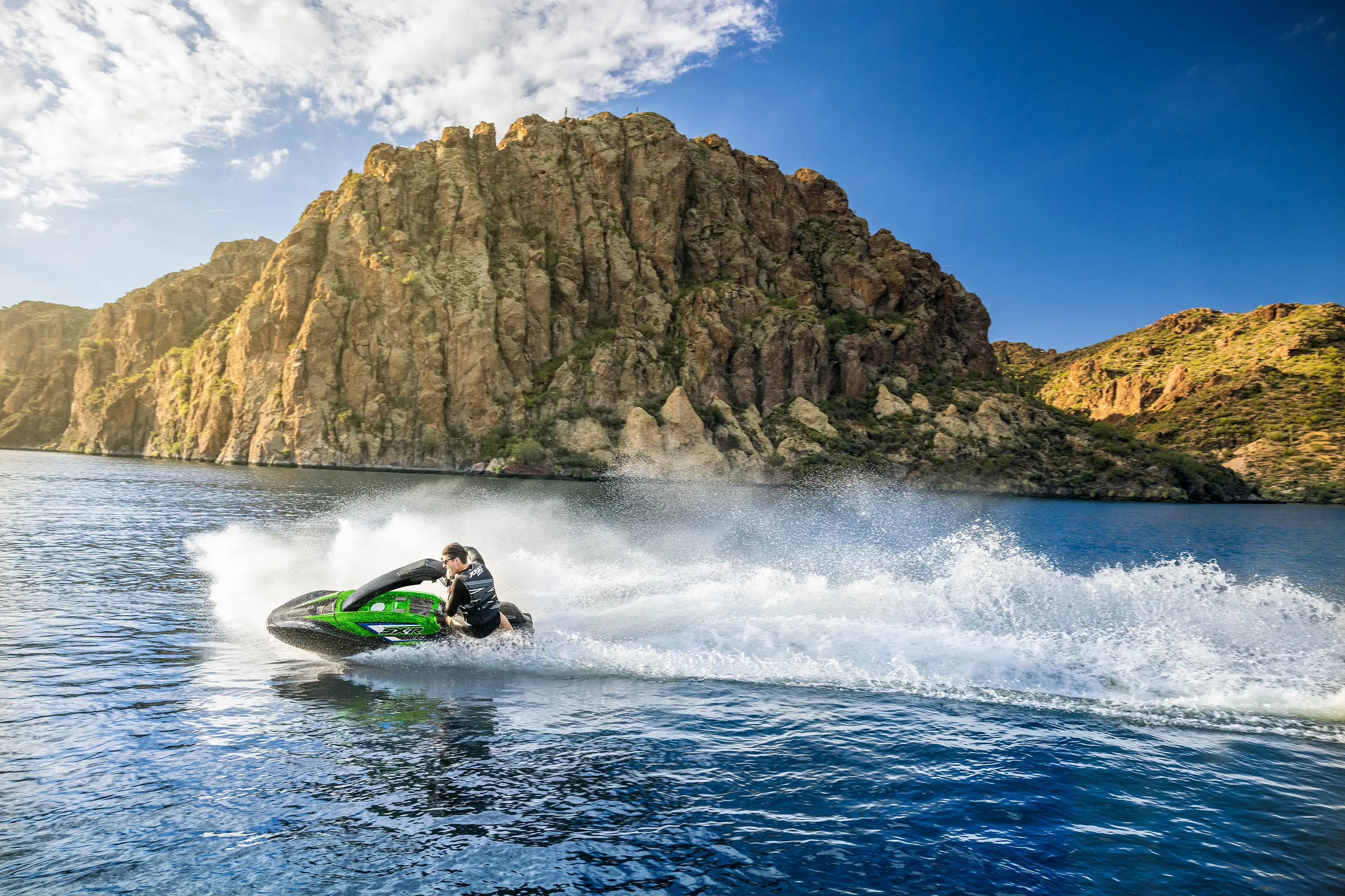 Profile angle of a person turning on a personal watercraft on the water.