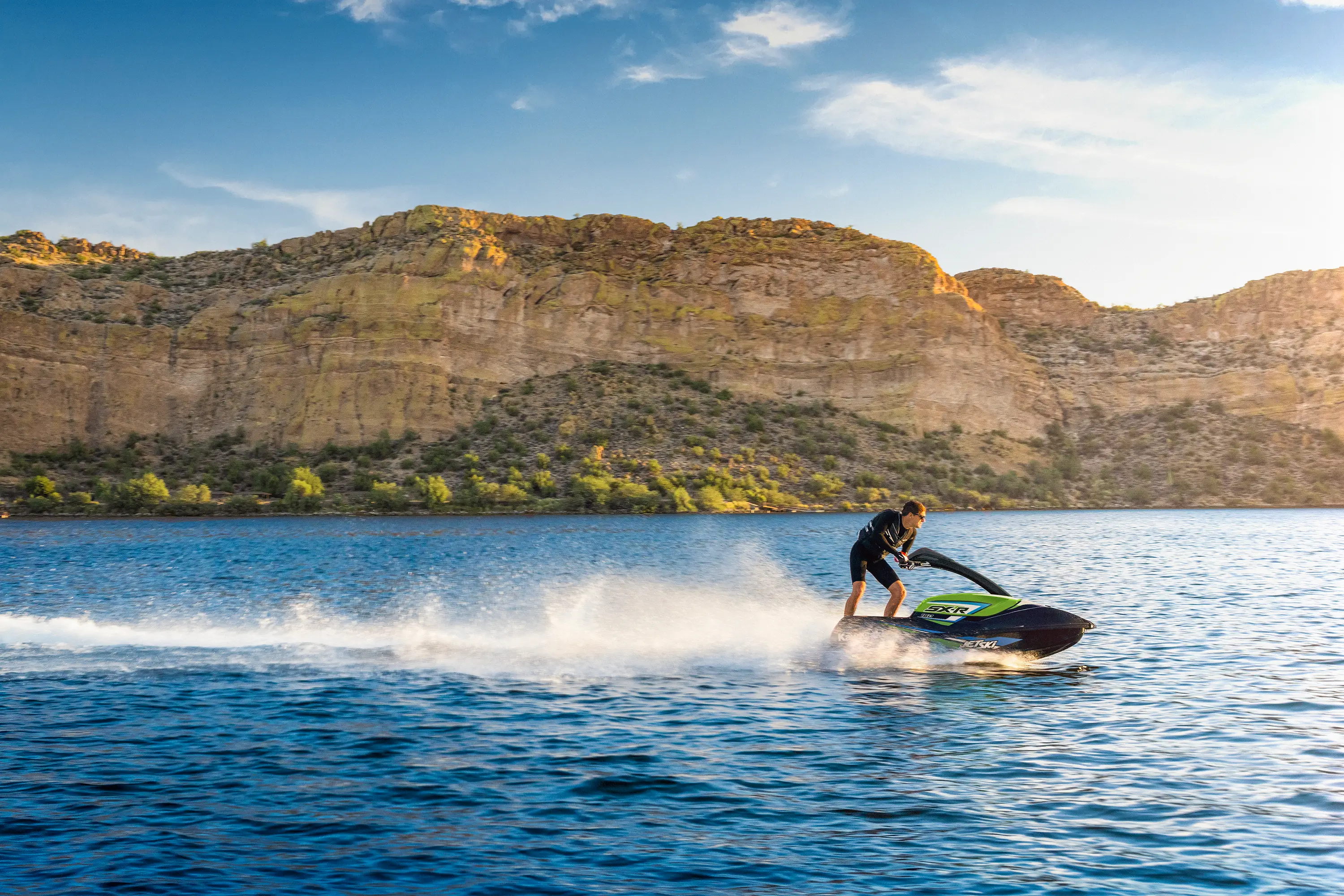 Side angle of a person on a personal watercraft on the water.