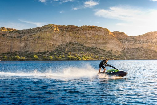 Side angle of a person on a personal watercraft on the water. opens in a new window