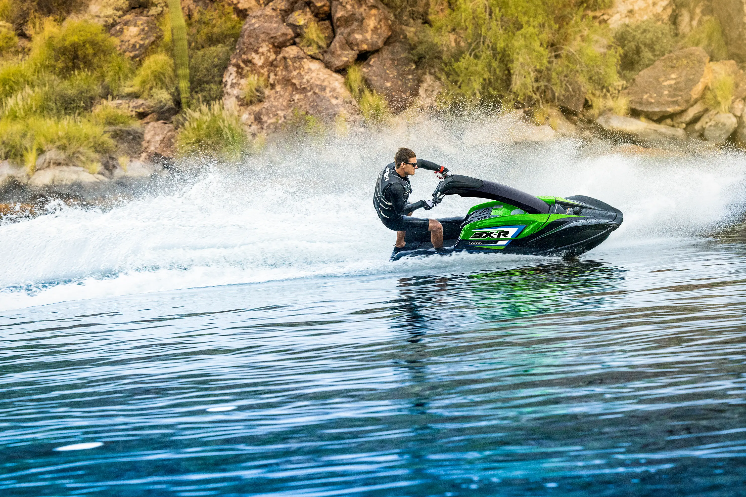 Profile angle of a person on a personal watercraft on the water.