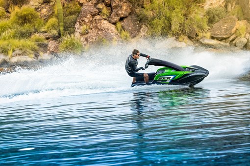 Profile angle of a person on a personal watercraft on the water. opens in a new window