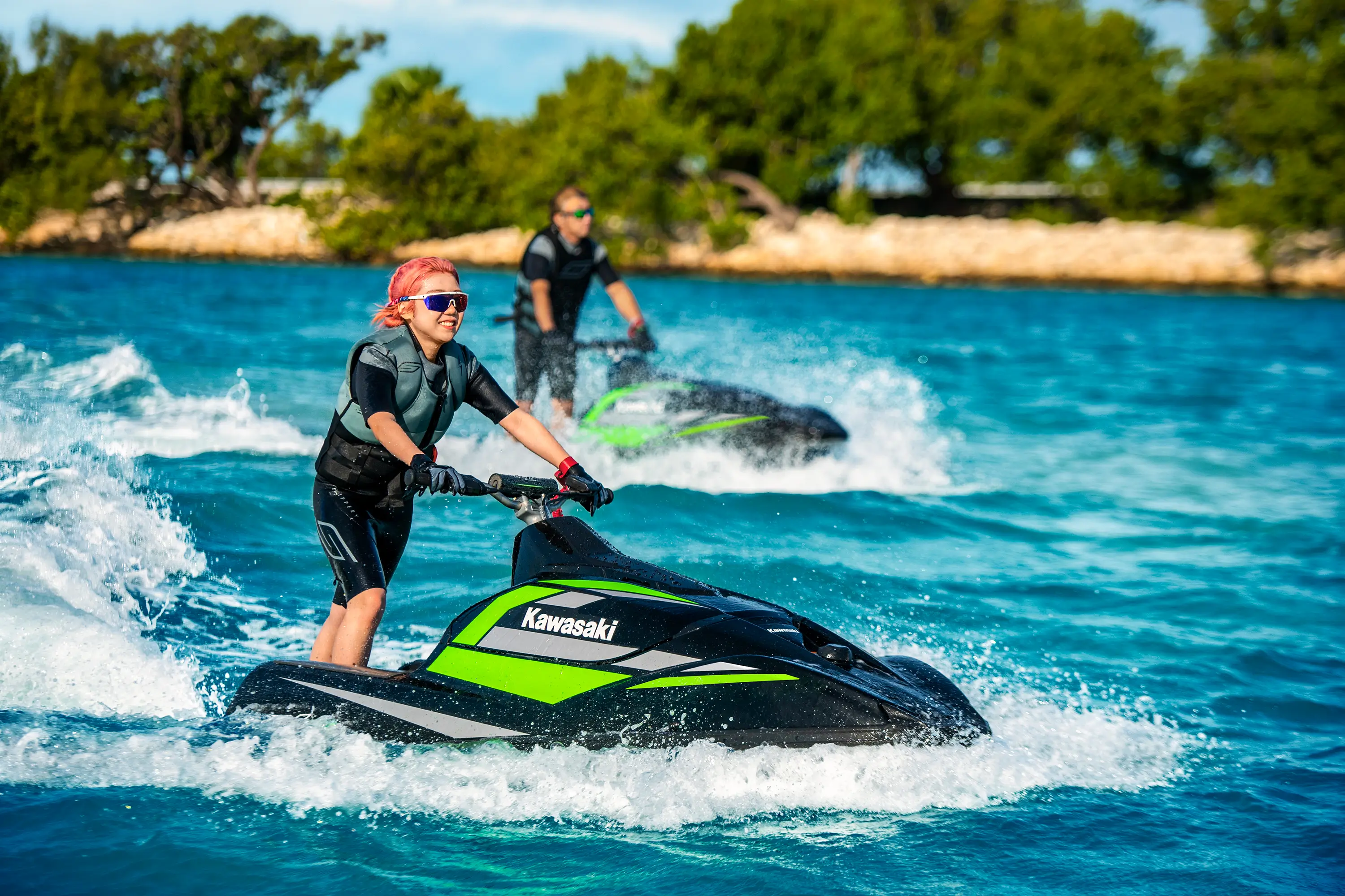 Two people on two person watercraft on the water.