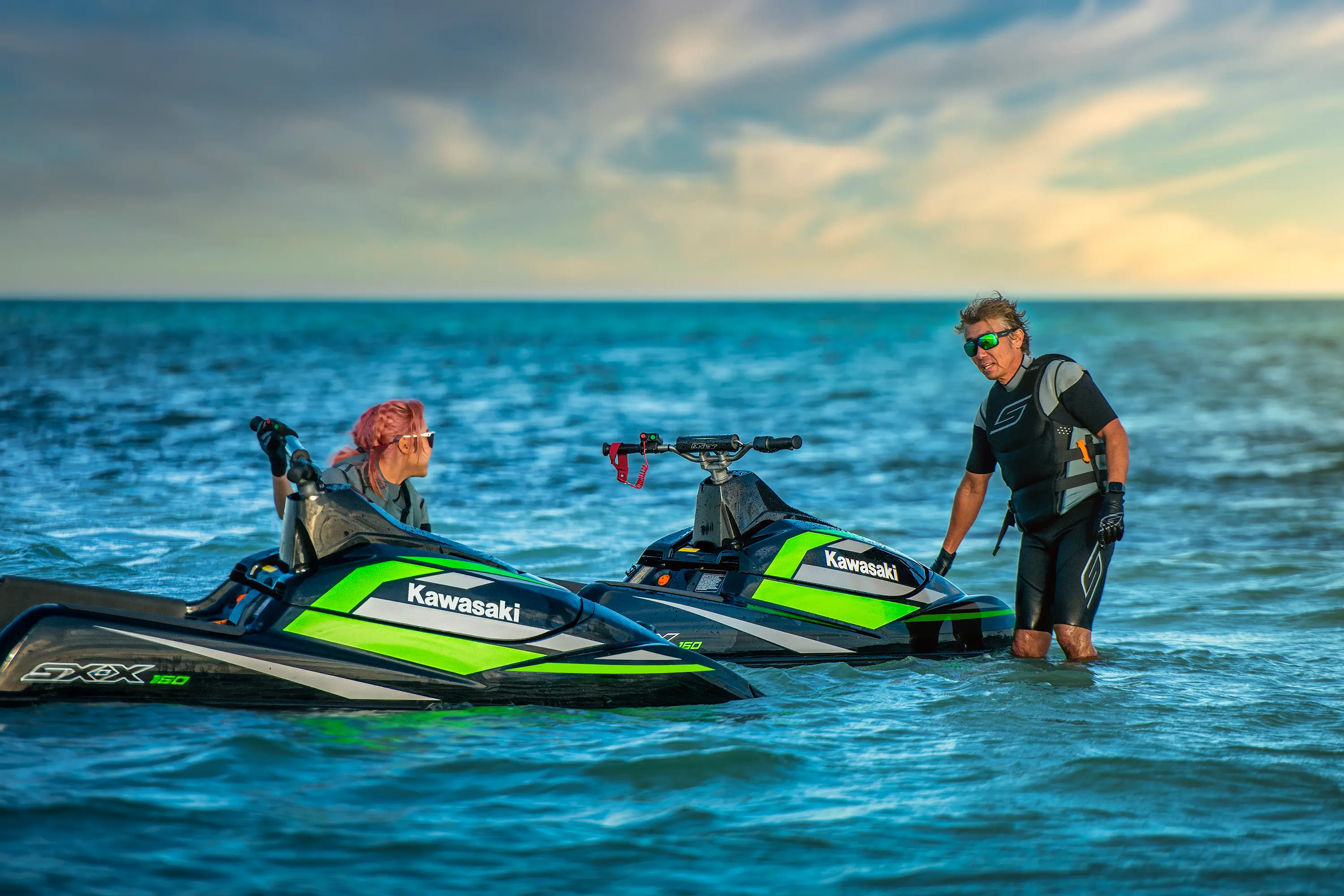 Two personal watercraft parked on the water.