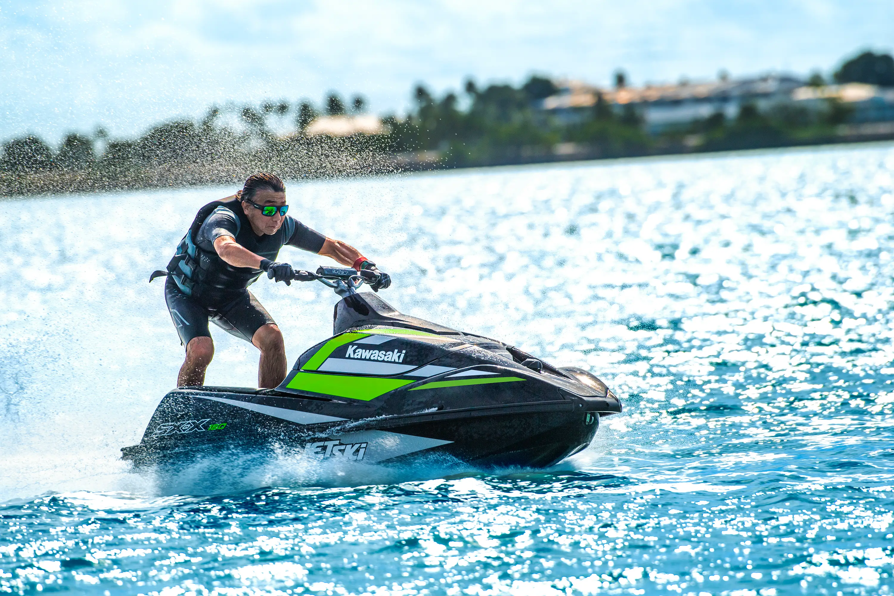 Side angle of a person on a personal watercraft on the water.