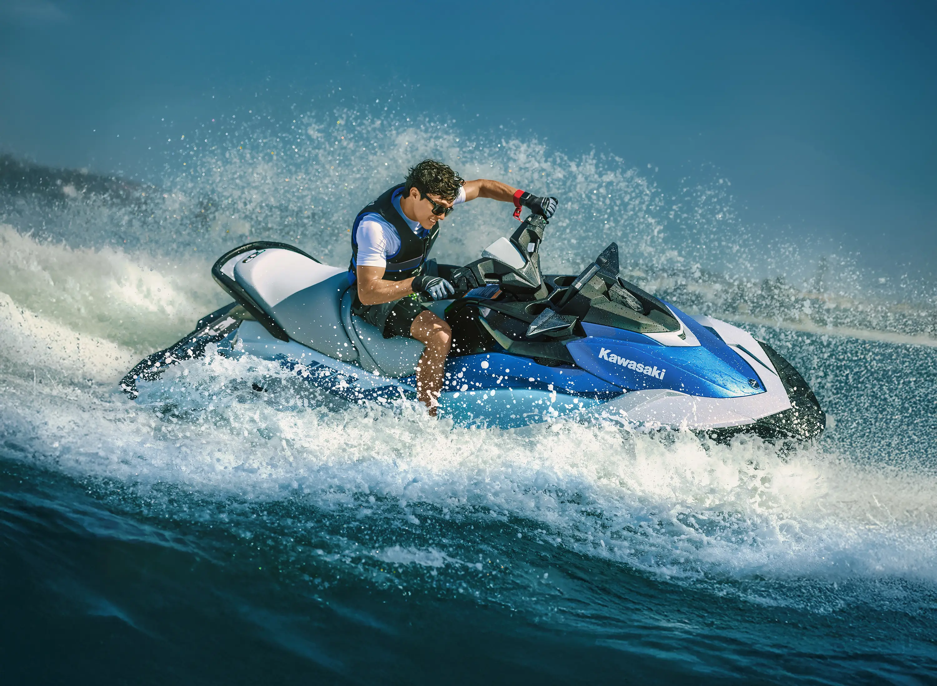 Side angle of a person turning on a personal watercraft on the water.