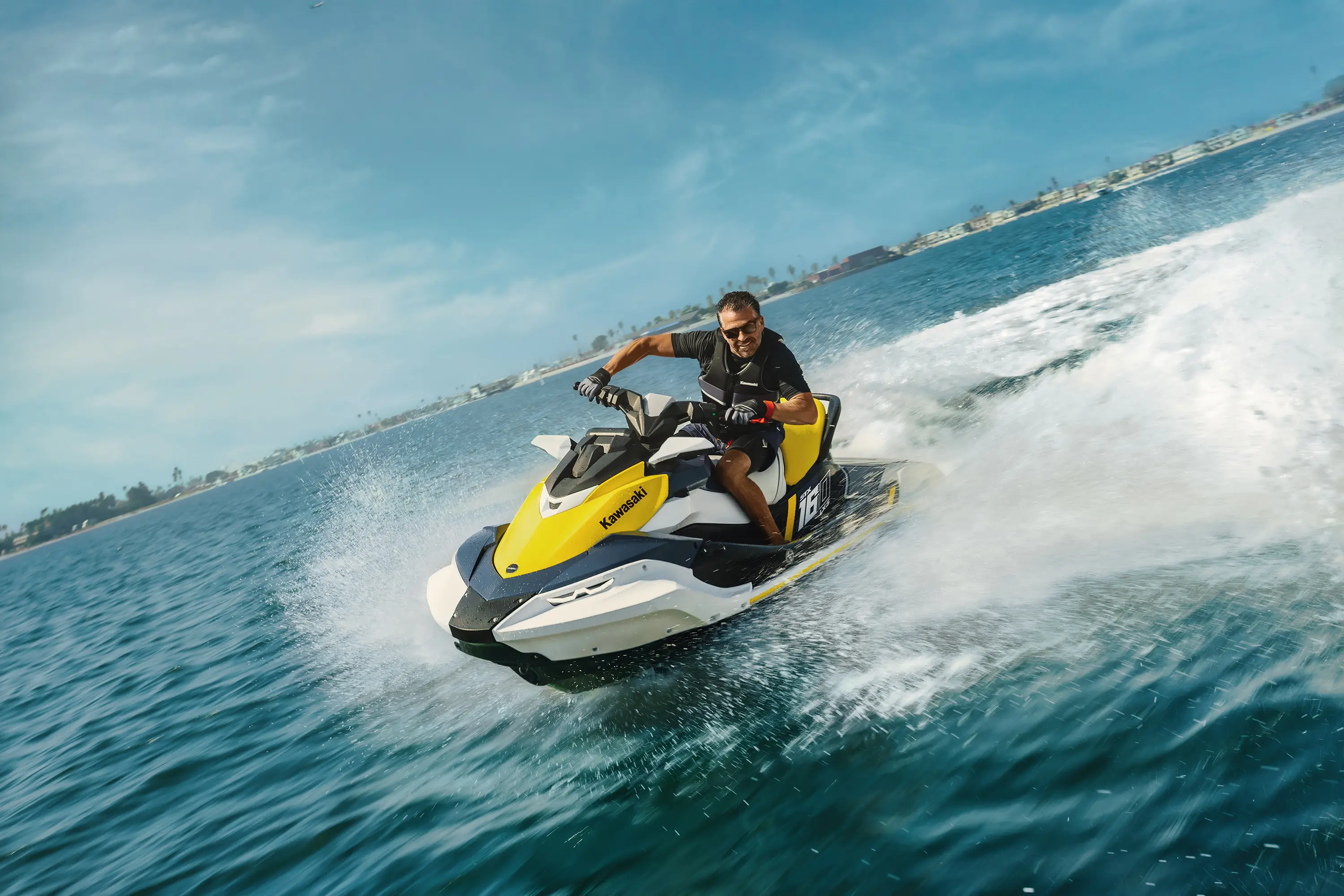 Three-quarter front angle of a person on a personal watercraft on the water.