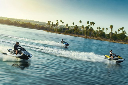 Overhead angle of 3 people on personal watercraft on the water. opens in a new window