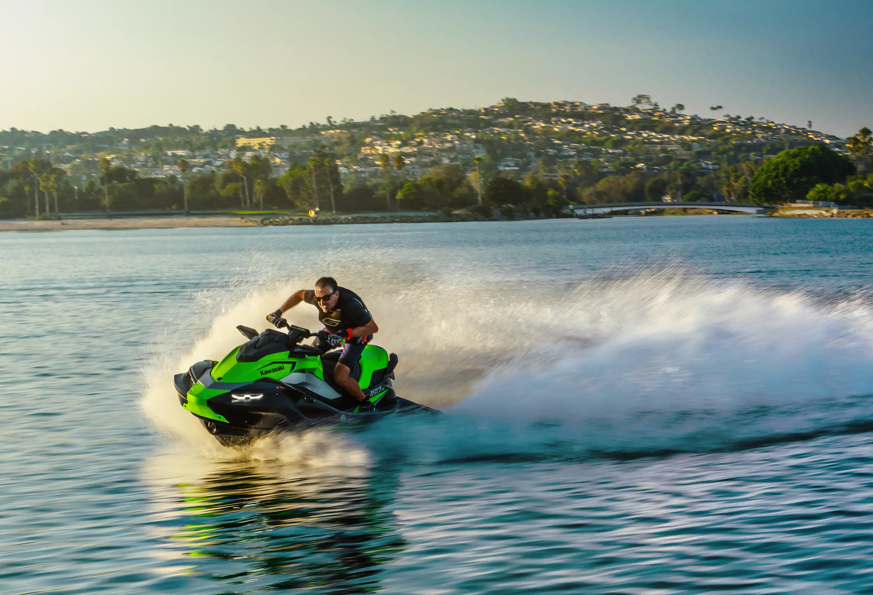 Front three-quarter angle of a person on a personal watercraft on the water.