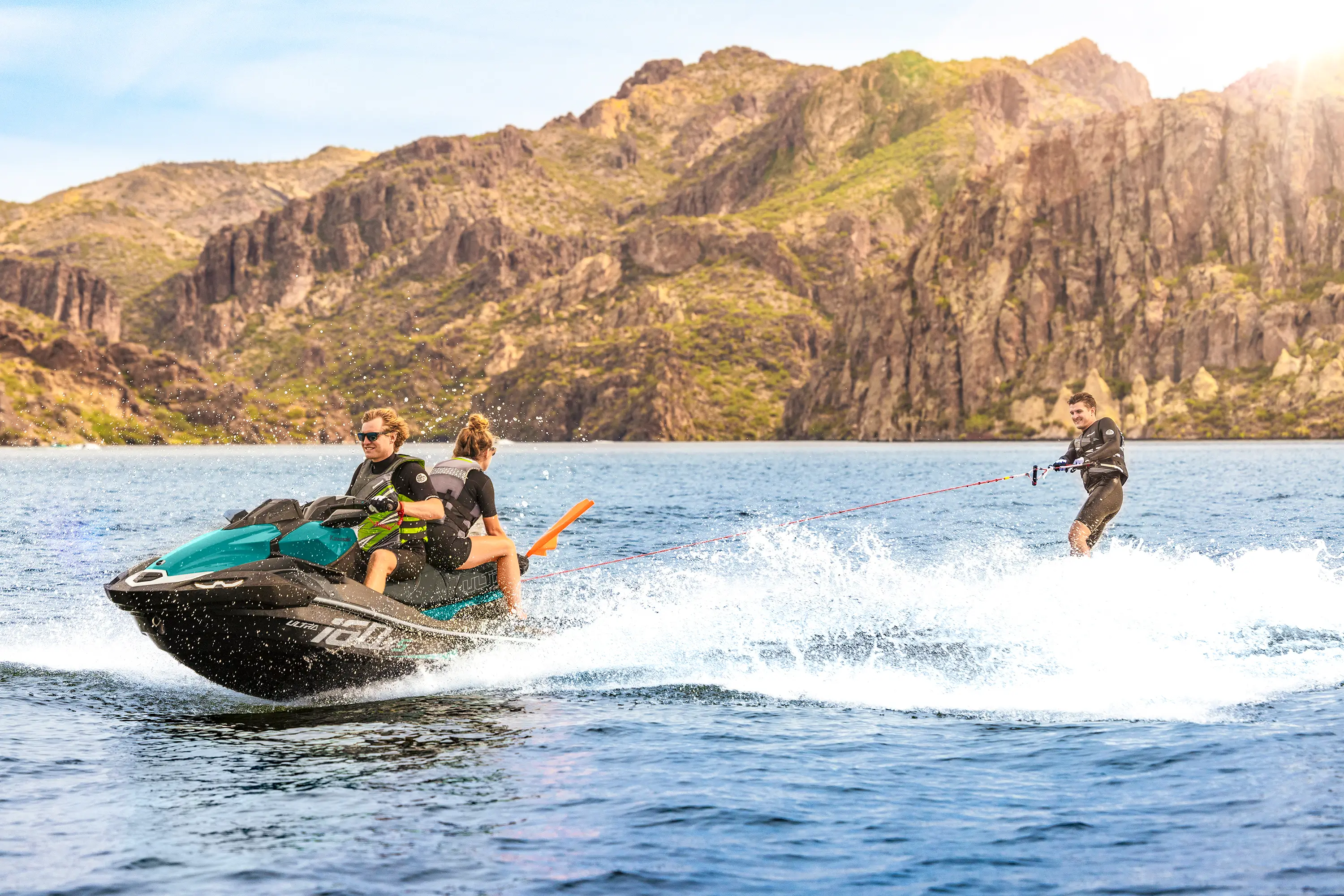 Side angle of a person towed behind a personal watercraft on the water.