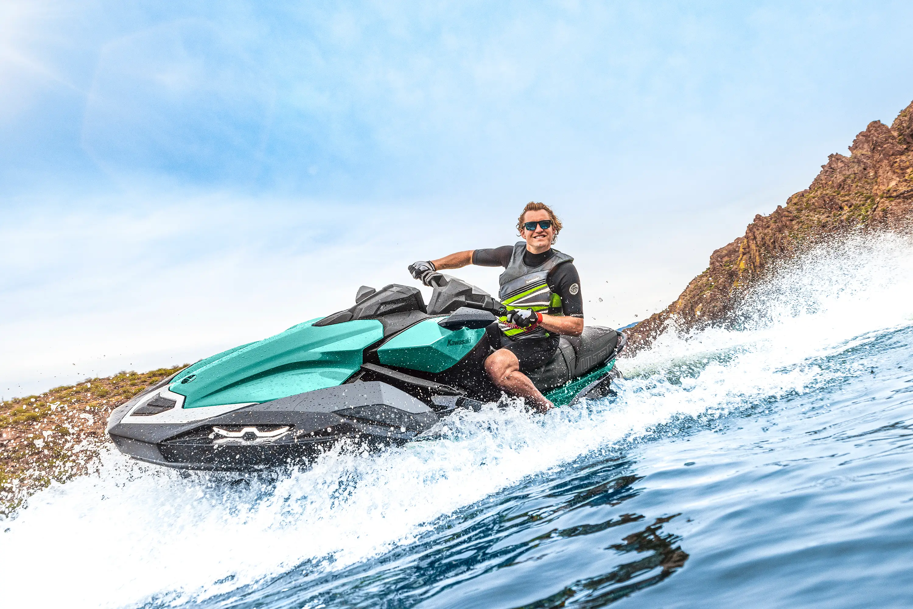 Three-quarter front angle of a person on a personal watercraft on the water.