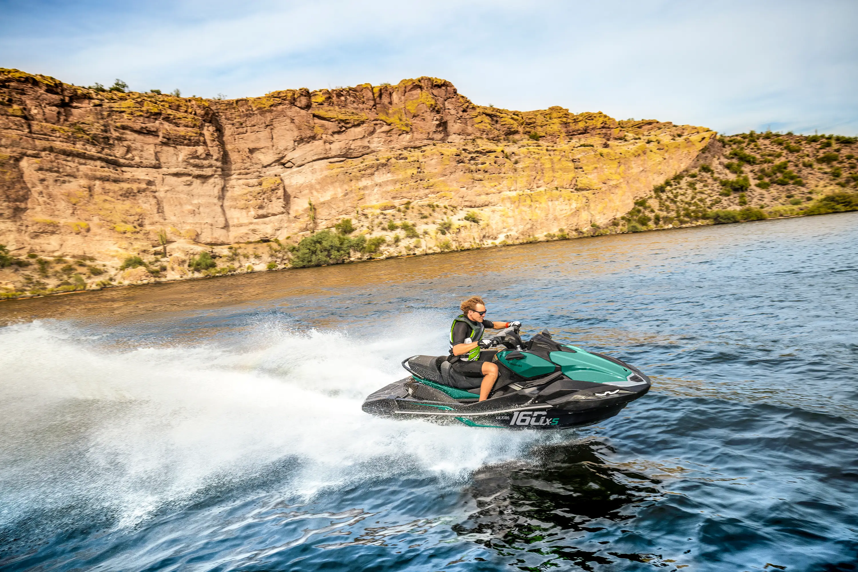 Profile angle of a person on a personal watercraft on the water.