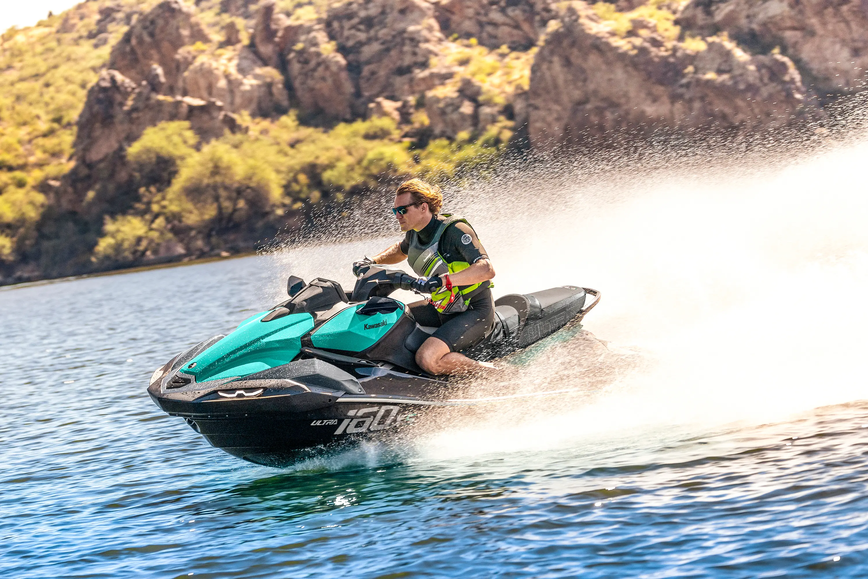 Side angle of a person on a personal watercraft on the water.