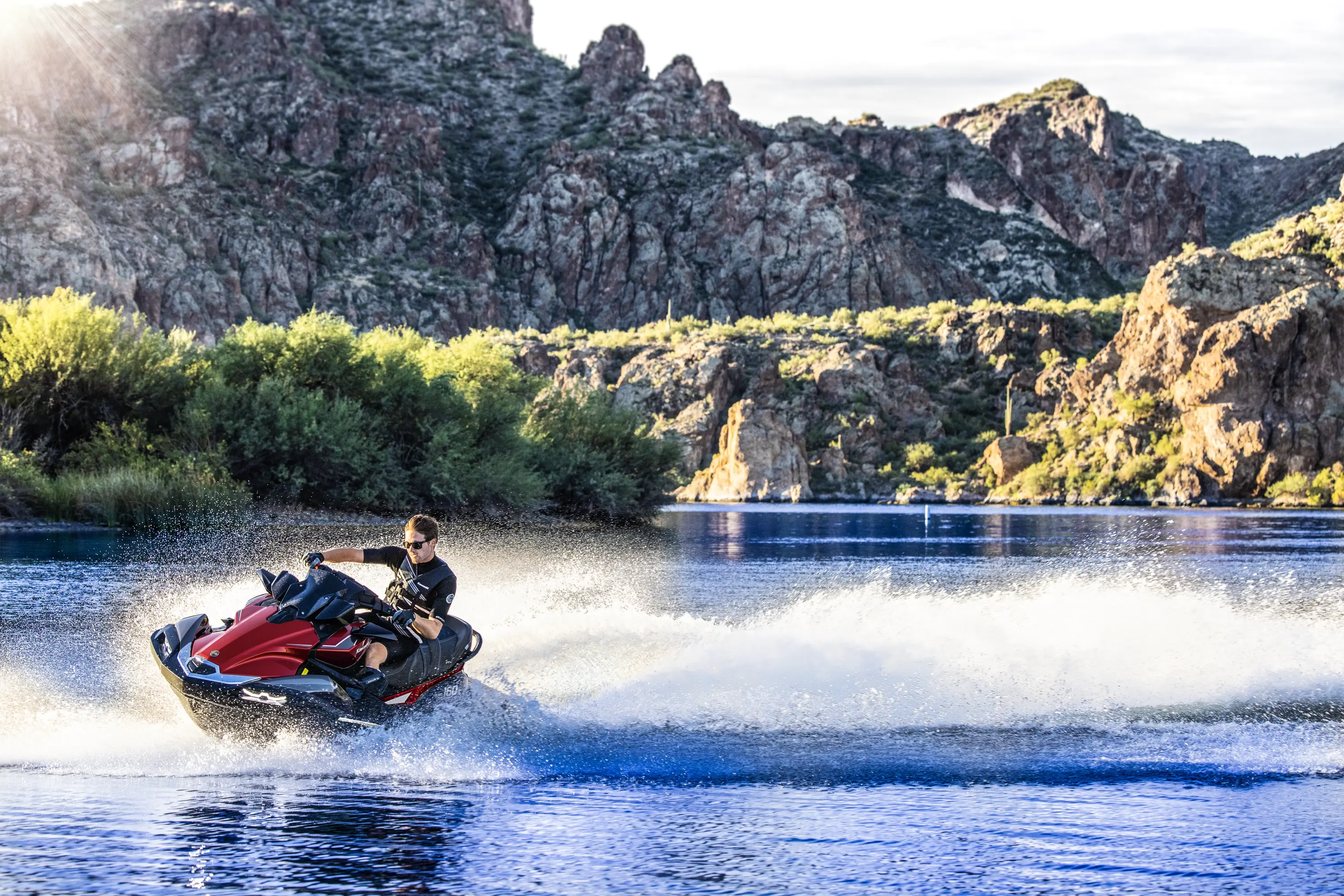 Person turning a personal watercraft on the water near shore.