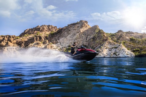 Side angle of a person on a personal watercraft on the water. opens in a new window