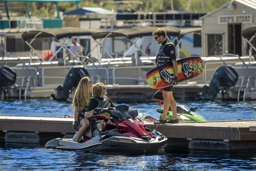3 people at a dock with a personal watercraft on the water. opens in a new window