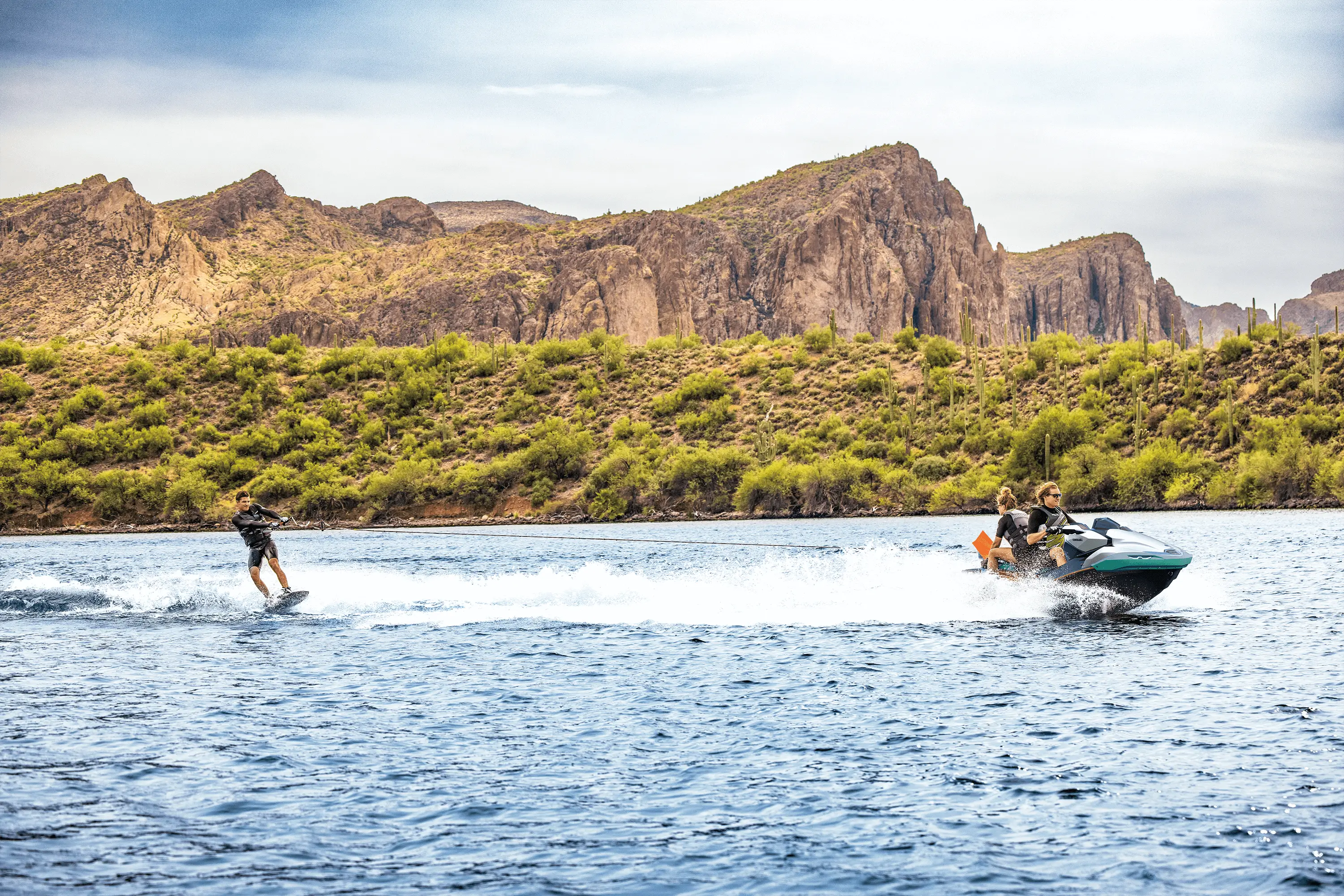 Side angle of a person being towed behind a personal watercraft on a lake.