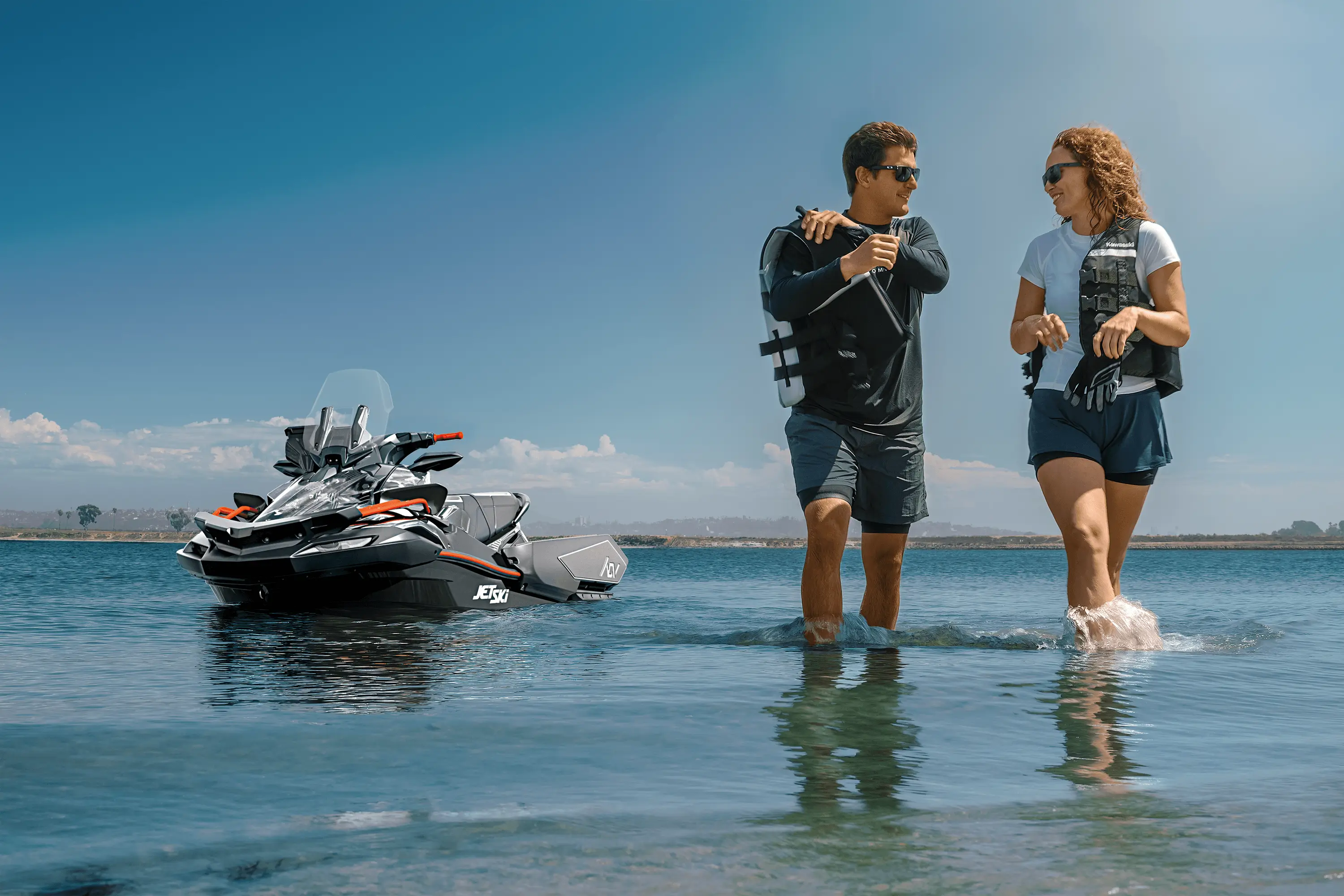 2 people walking away from a personal watercraft sitting on the water.