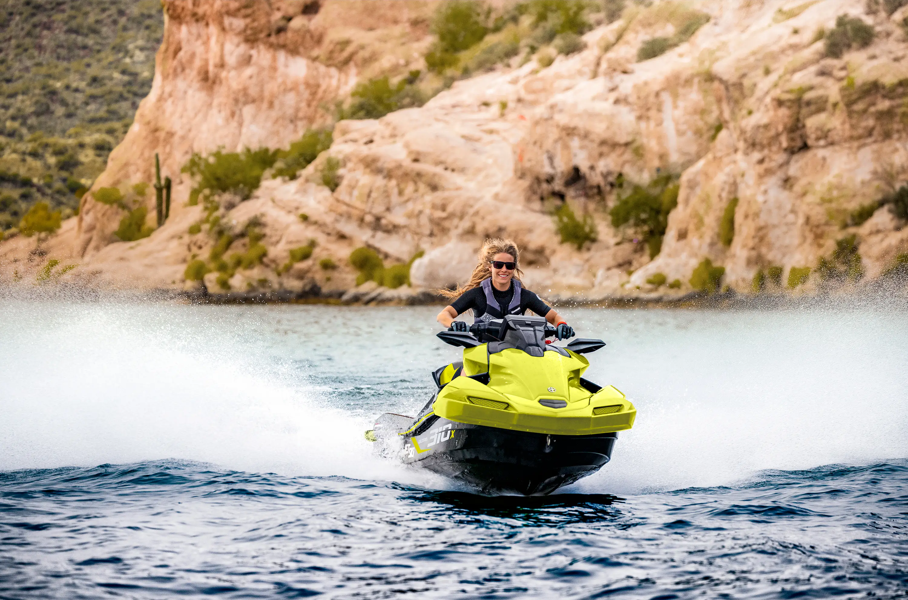 Front angle of a person on a personal watercraft on the water.