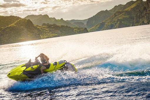 Person turning a personal watercraft on the water at sunset. opens in a new window