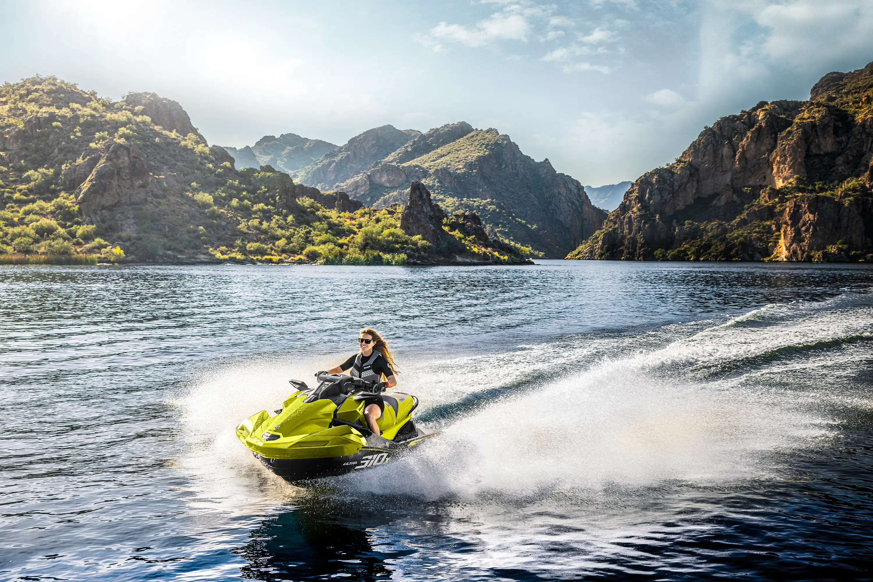 Three-quarter front angle of a person on a personal watercraft on the water.