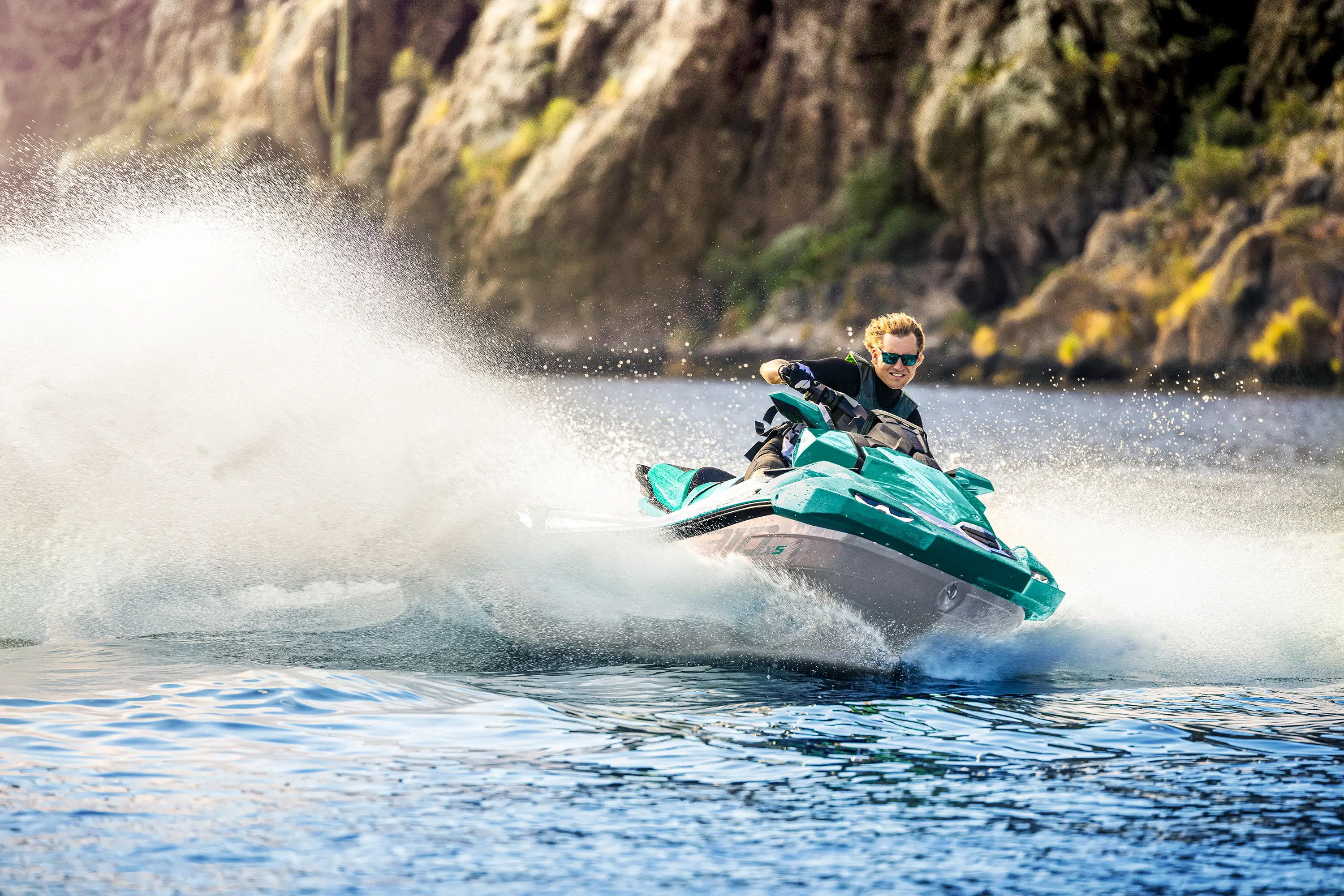 Three-quarter front angle of a person turning on a personal watercraft on the water.