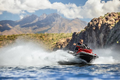 Three-quarter front angle of a person on a personal watercraft on the water. opens in a new window