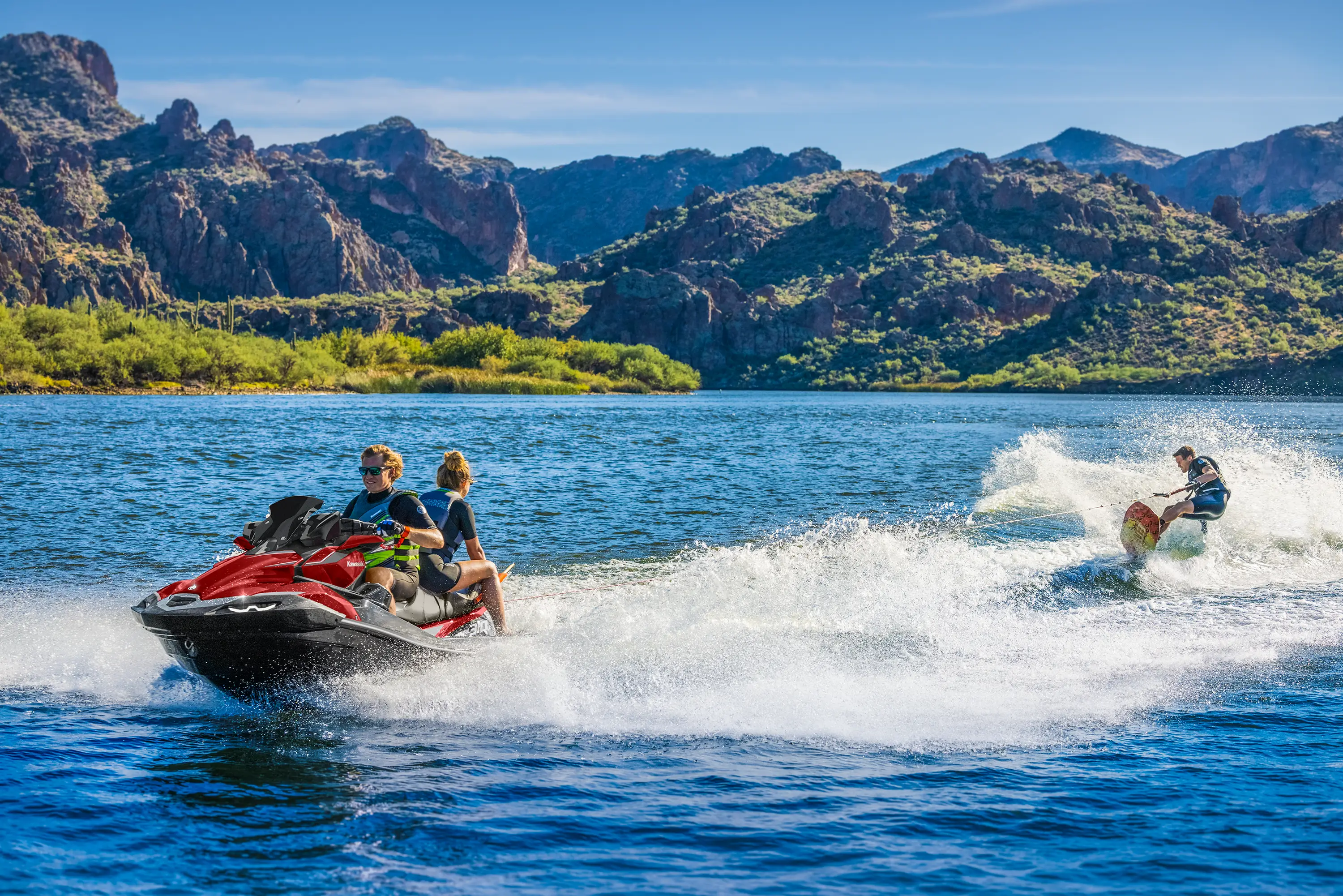 Front three-quarter angle of a person being towed behind a personal watercraft on the water.