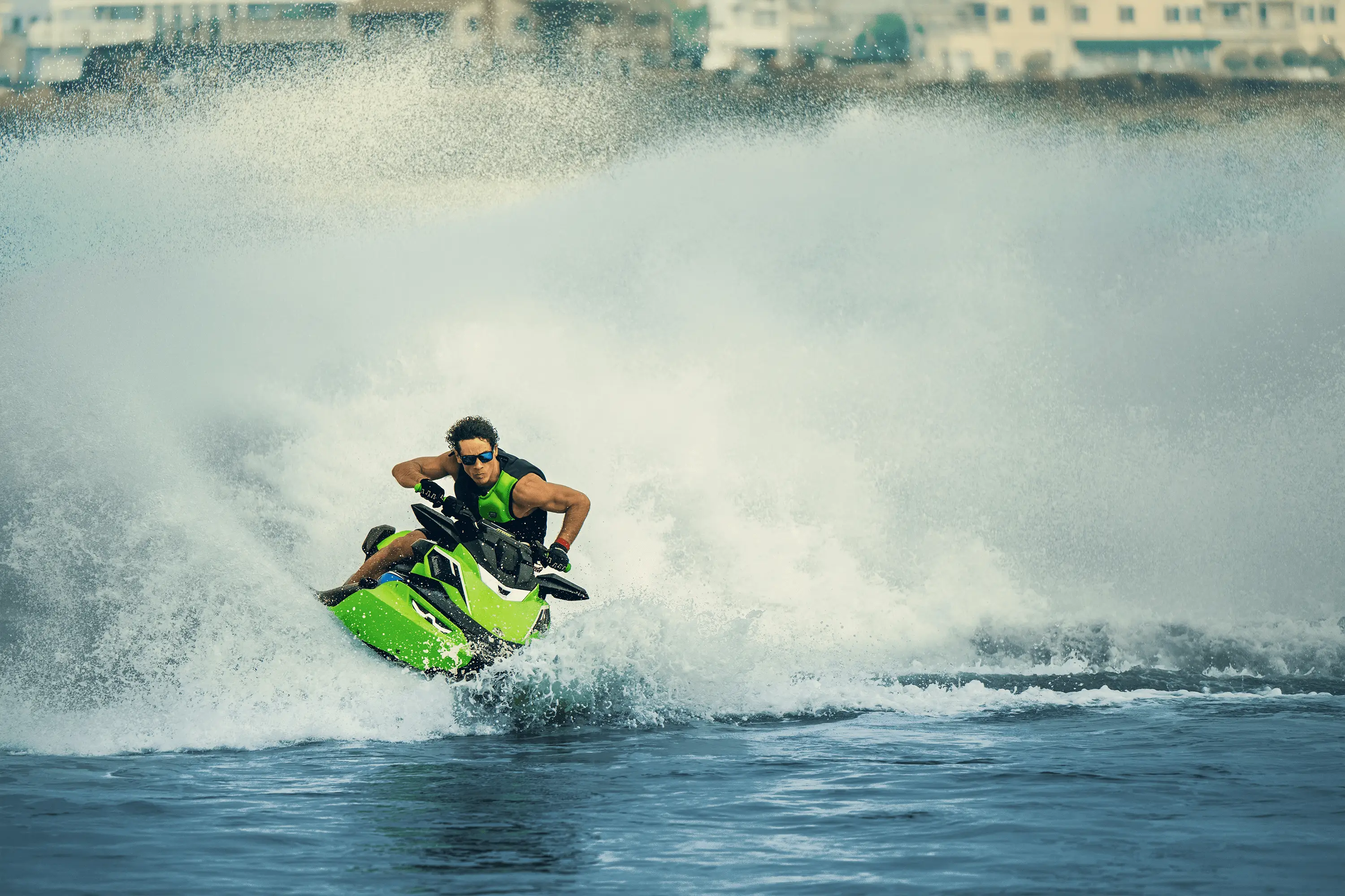 Front angle of a person on a personal watercraft on the water.