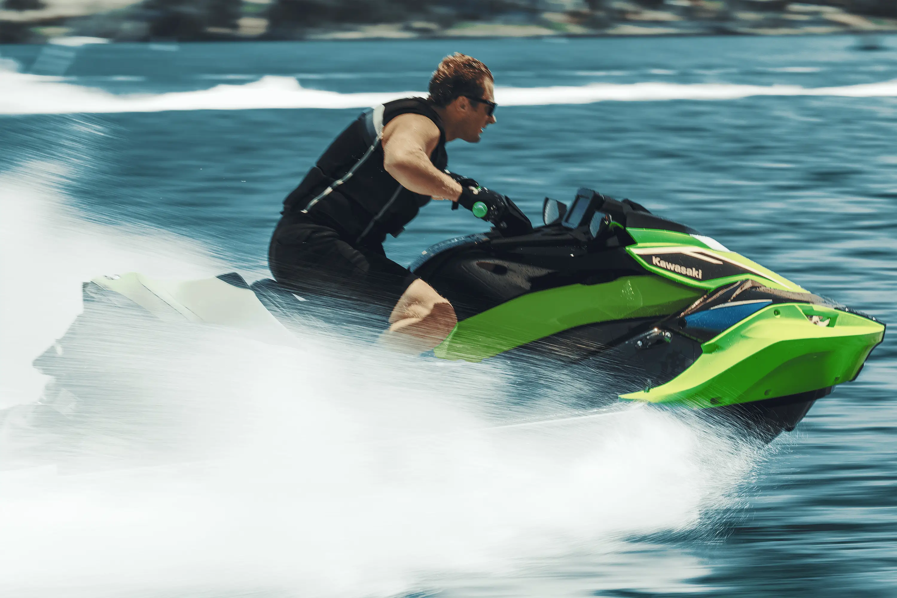 Side angle of a person on a personal watercraft on the water.