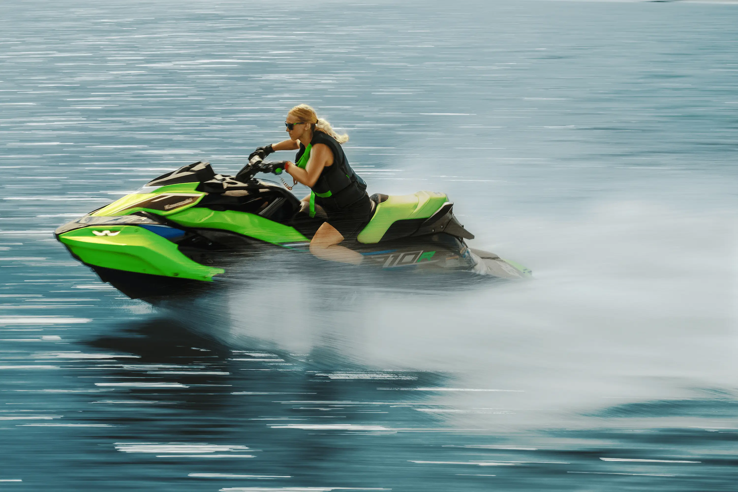 Profile angle of a person on a personal watercraft on the water.