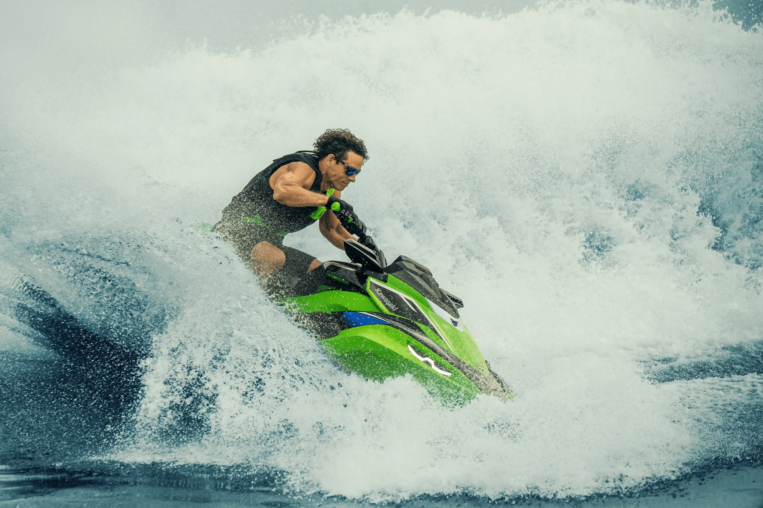 Profile angle of a person in a wave on a personal watercraft on the water.