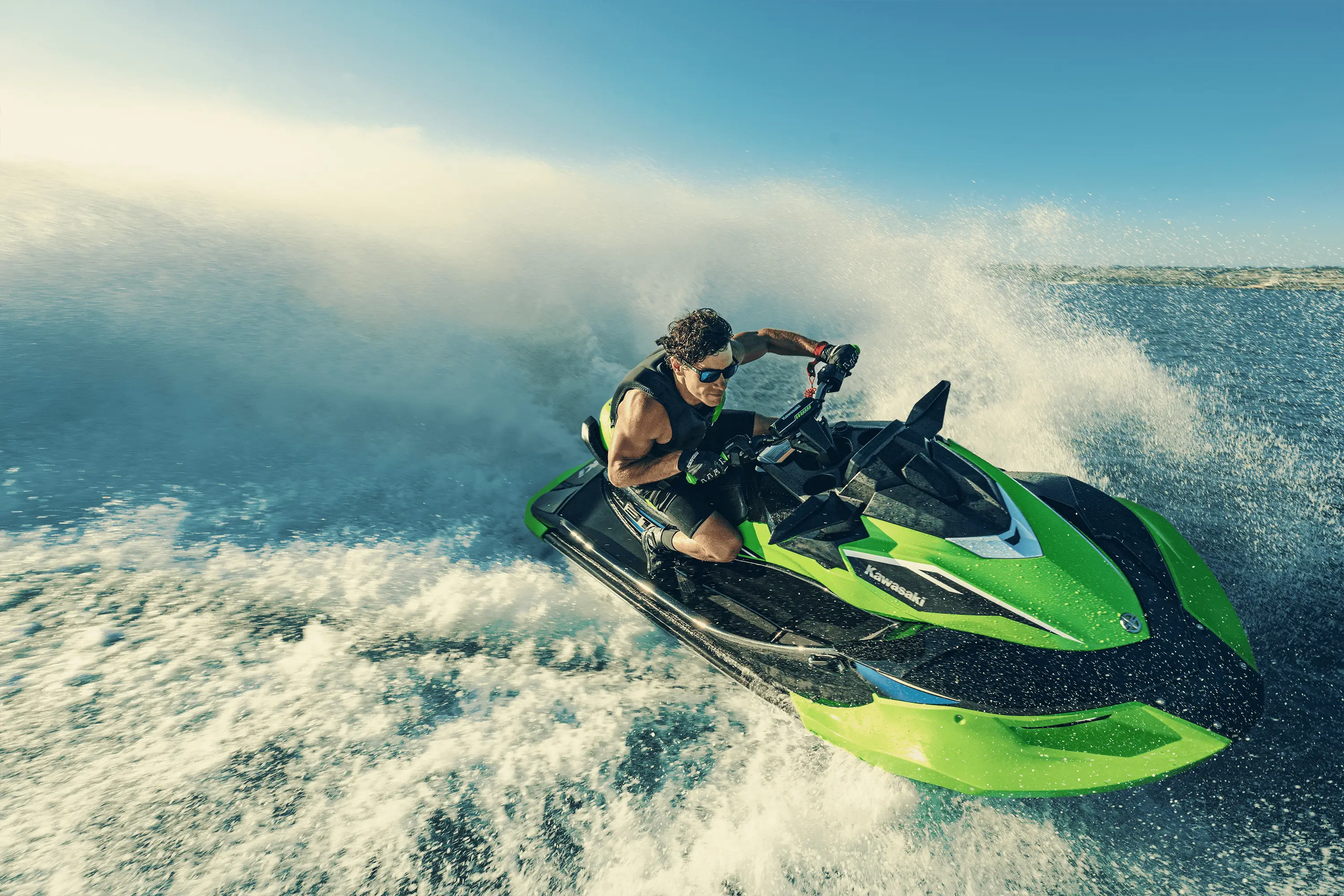 Three-quarter front angle of a person on a personal watercraft on the water.