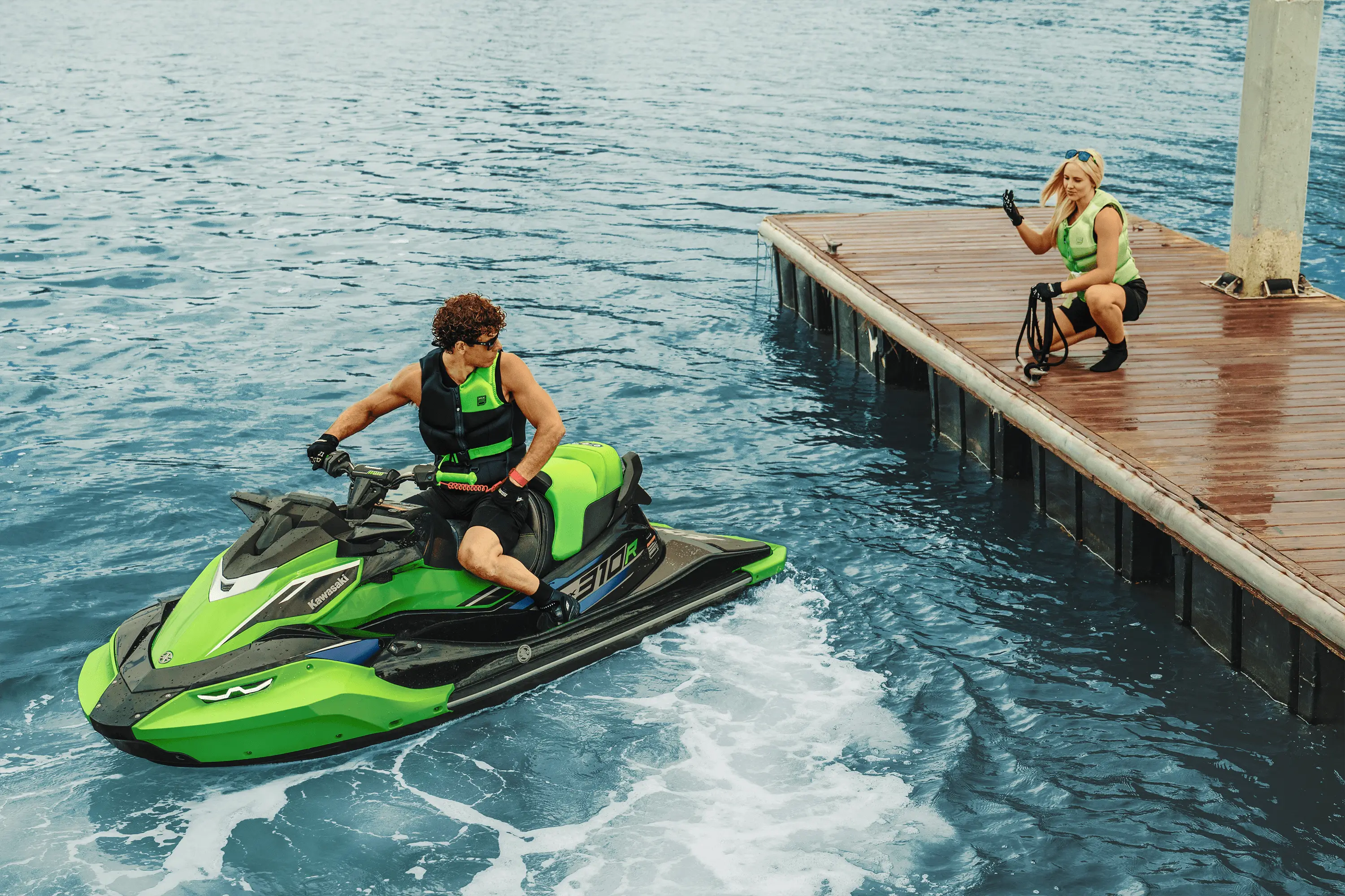 Person on a watercraft backing up to a dock.