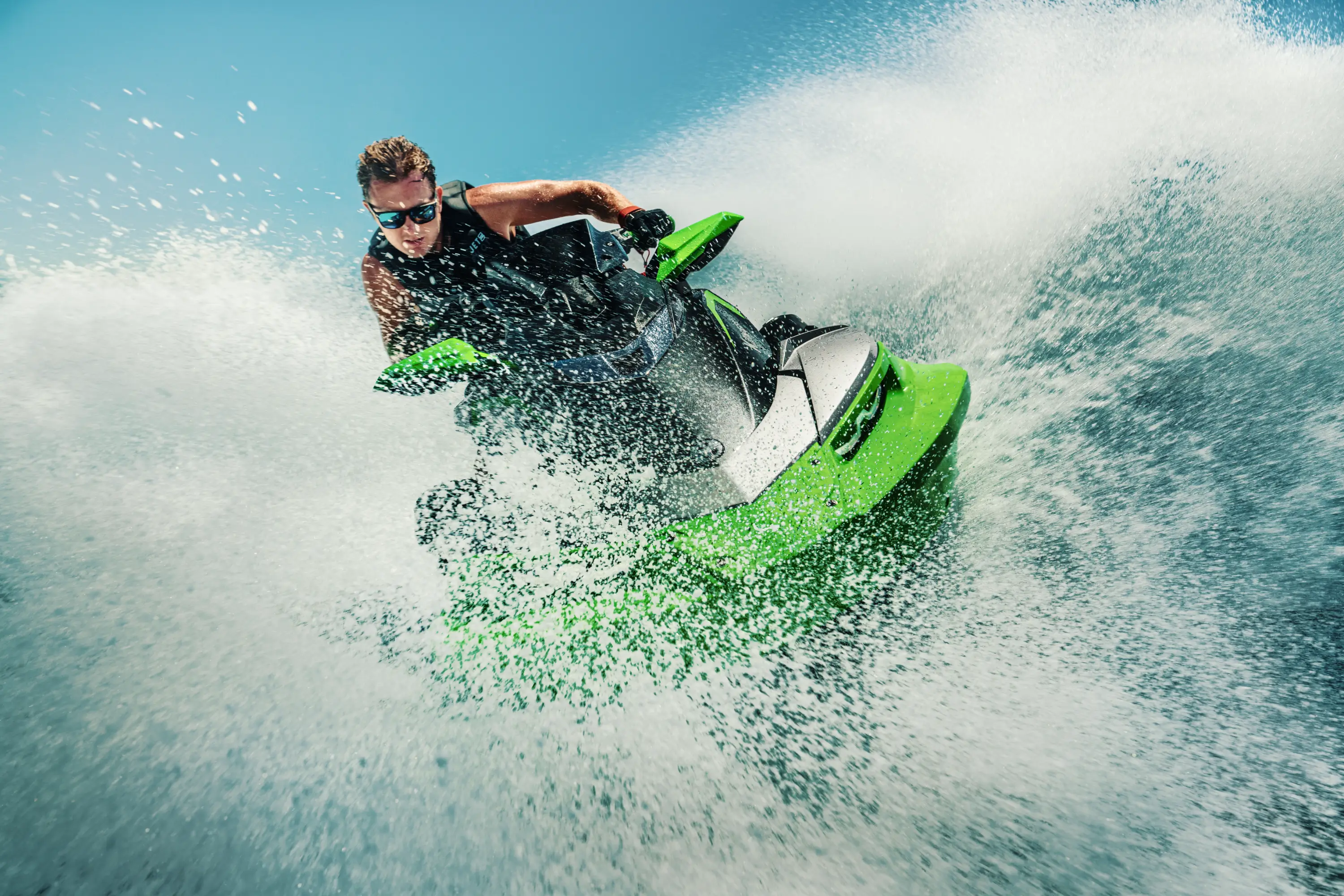 Front angle of a person on a personal watercraft on the water.