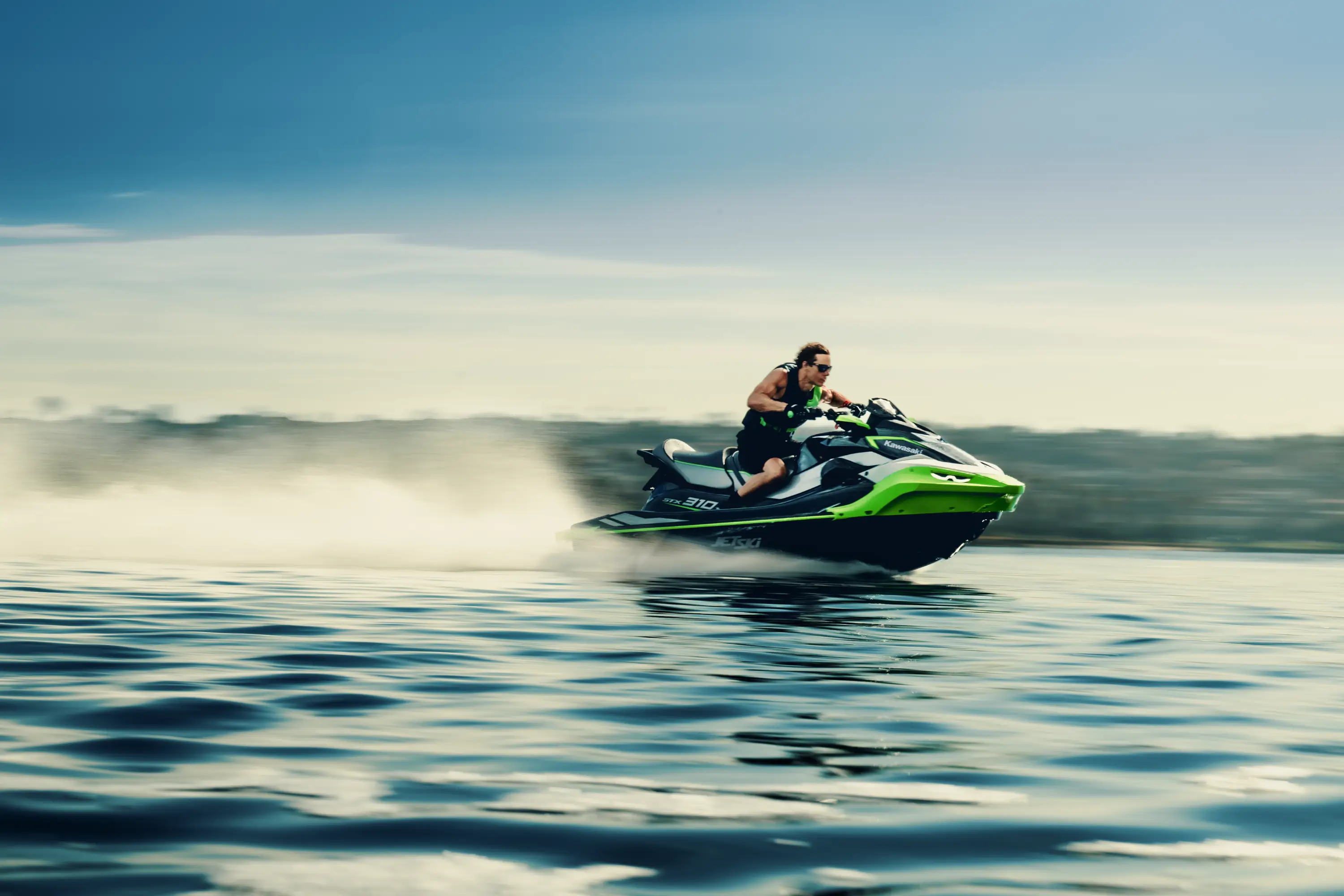 Three-quarter front angle of a person on a personal watercraft on the water.