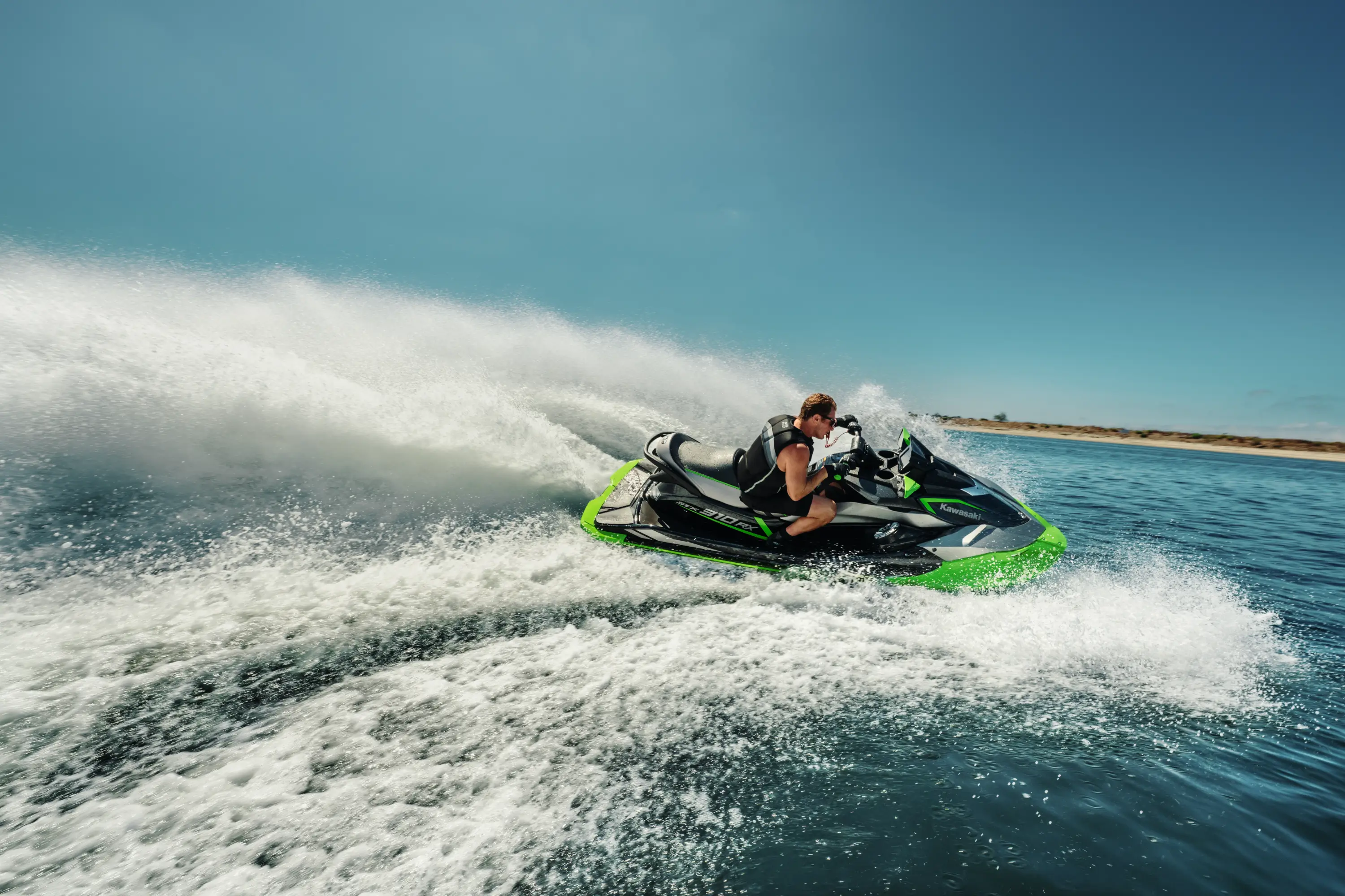 Side angle of a person on a personal watercraft on the water.