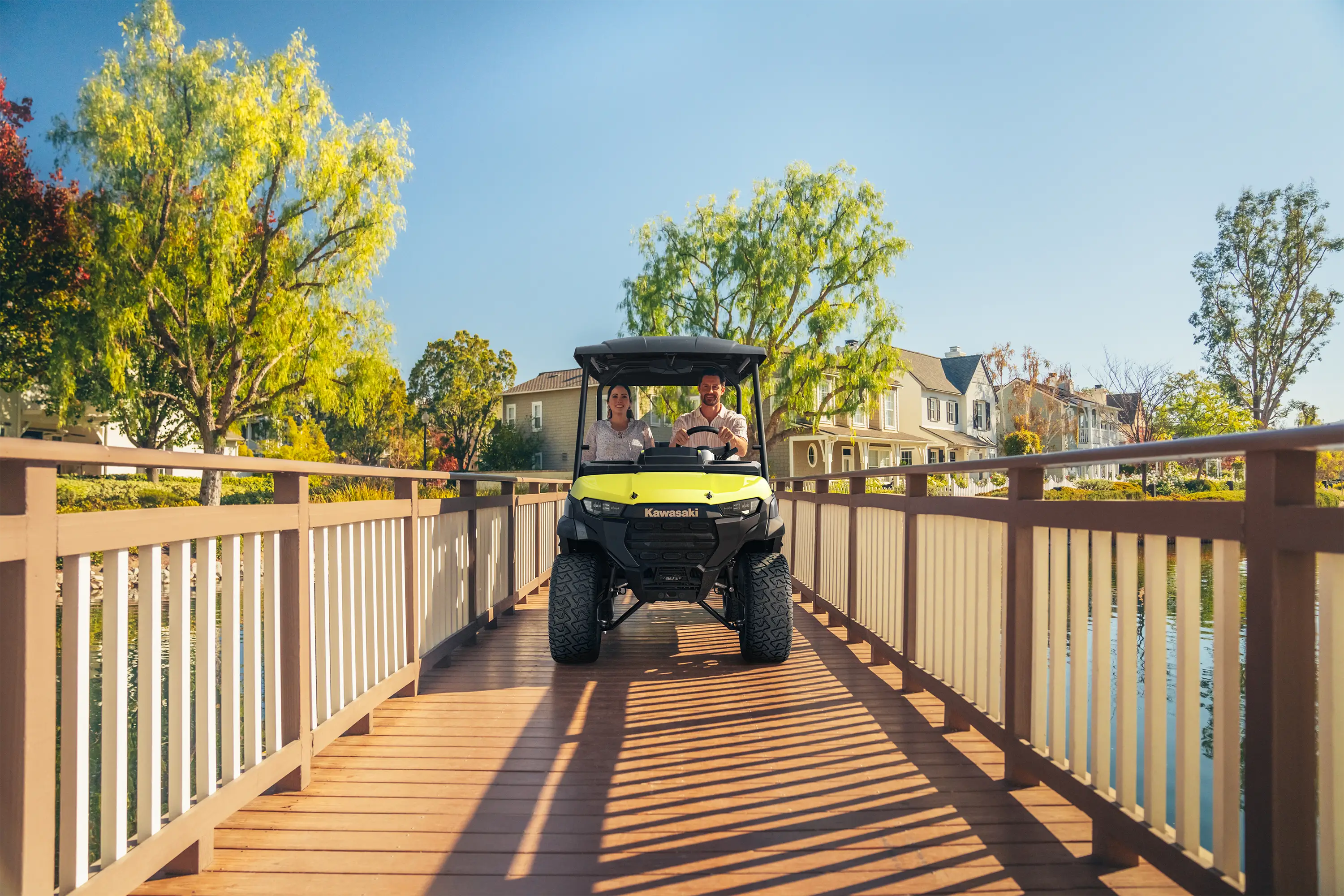 Front angle of a family riding in a Neighborhood Activity Vehicle on a community roadway.