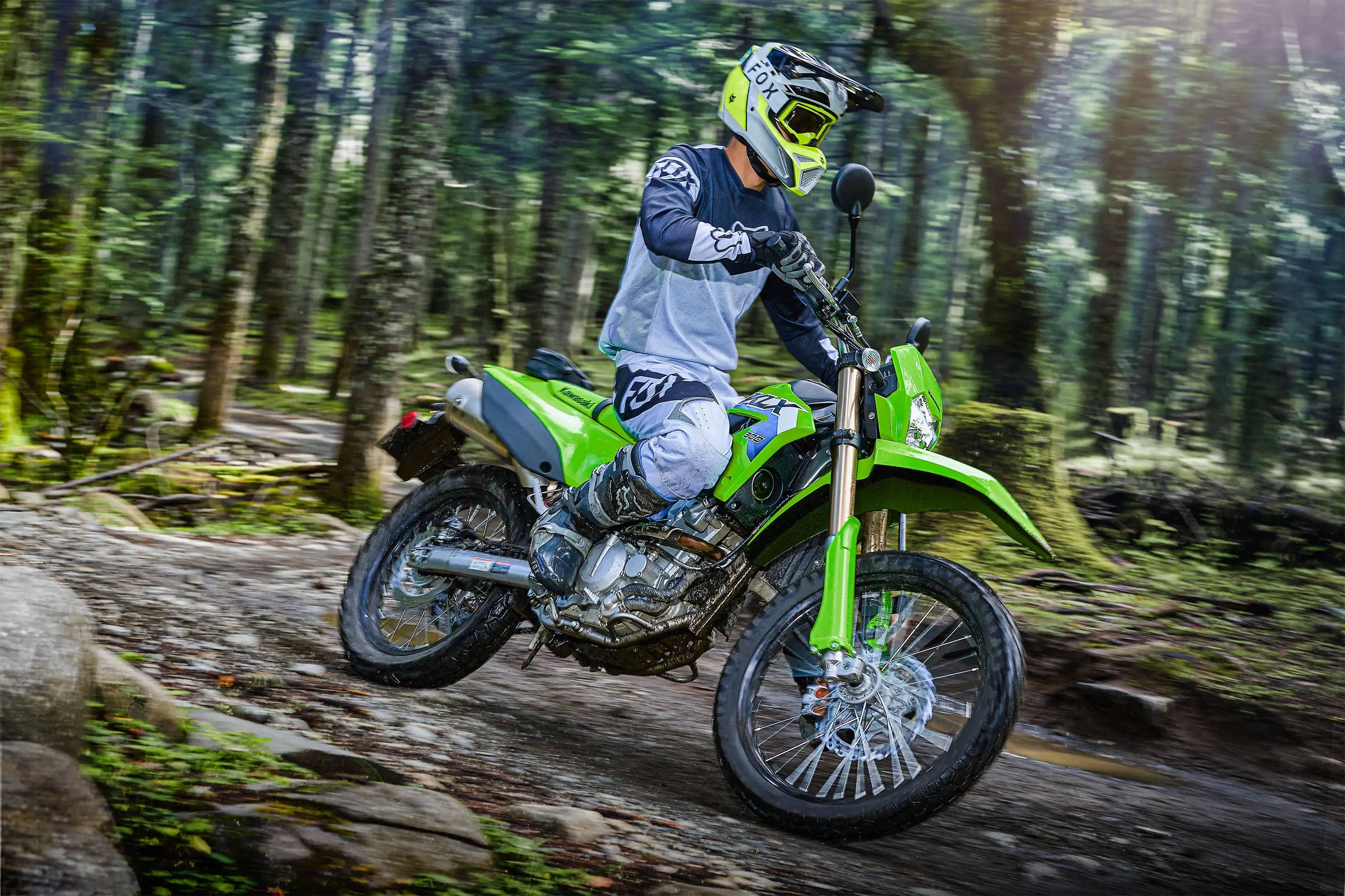 Side angle of a person riding a motorcycle on a trail.