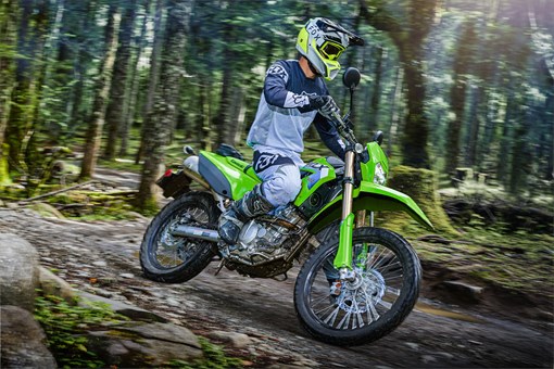 Side angle of a person riding a motorcycle on a trail. opens in a new window