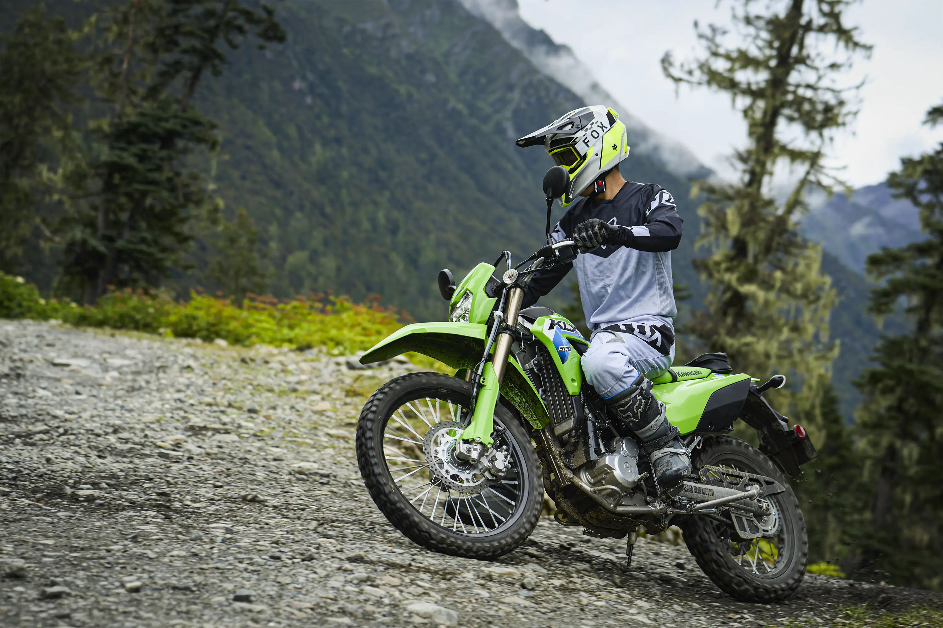 Side angle of a person riding a motorcycle off-road.