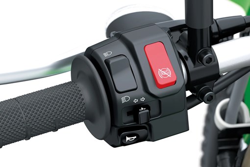 Red switch on the handlebar of a motorcycle staged in a white studio background. opens in a new window