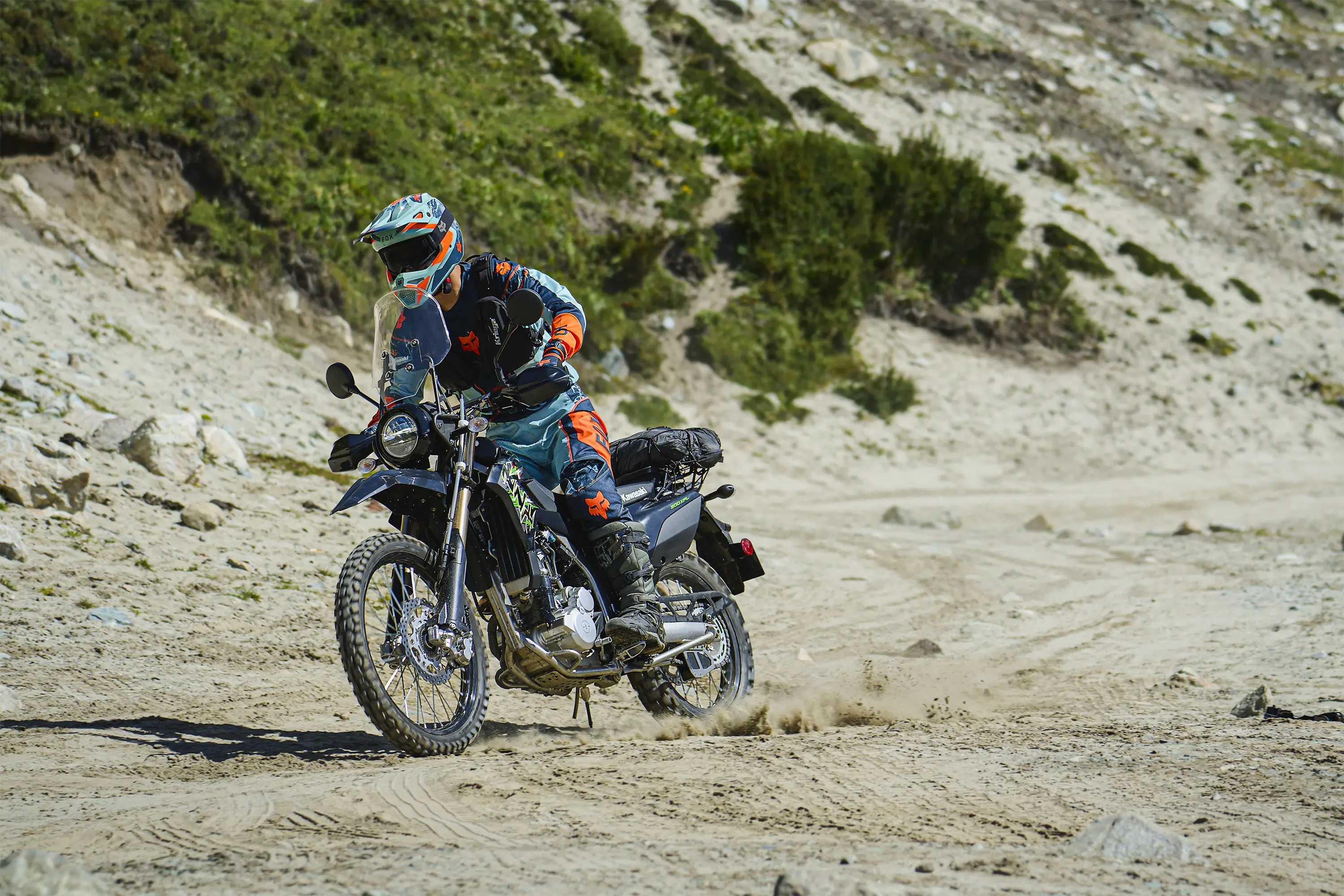 Three-quarter front angle of a person riding a motorcycle off-road.
