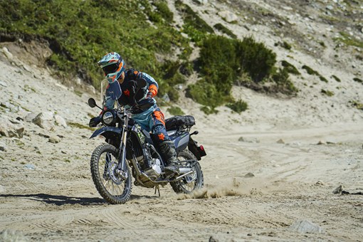Three-quarter front angle of a person riding a motorcycle off-road. opens in a new window