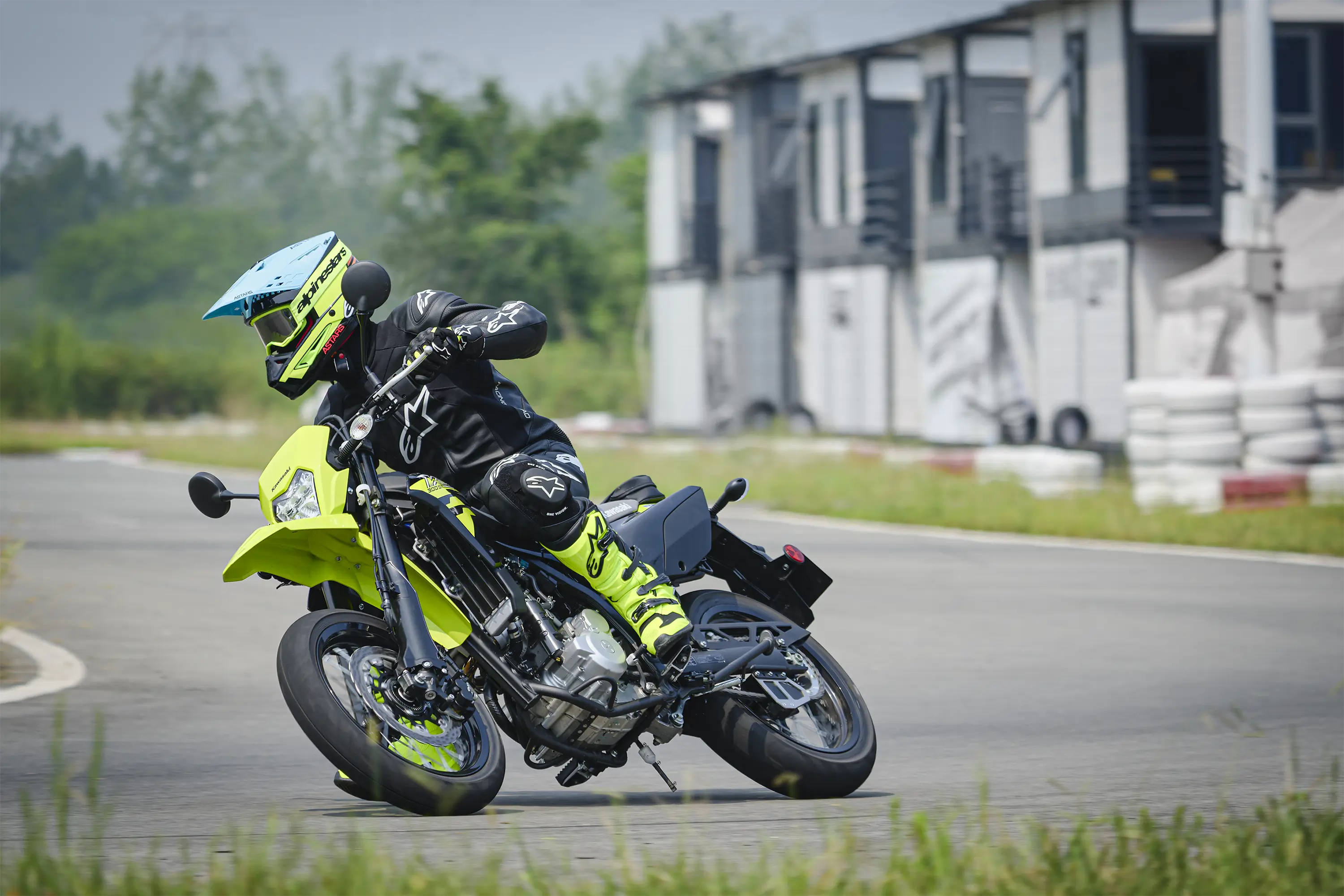 Three-quarter front angle of a person riding a motorcycle on a track.