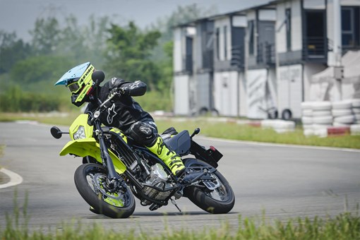 Three-quarter front angle of a person riding a motorcycle on a track. opens in a new window