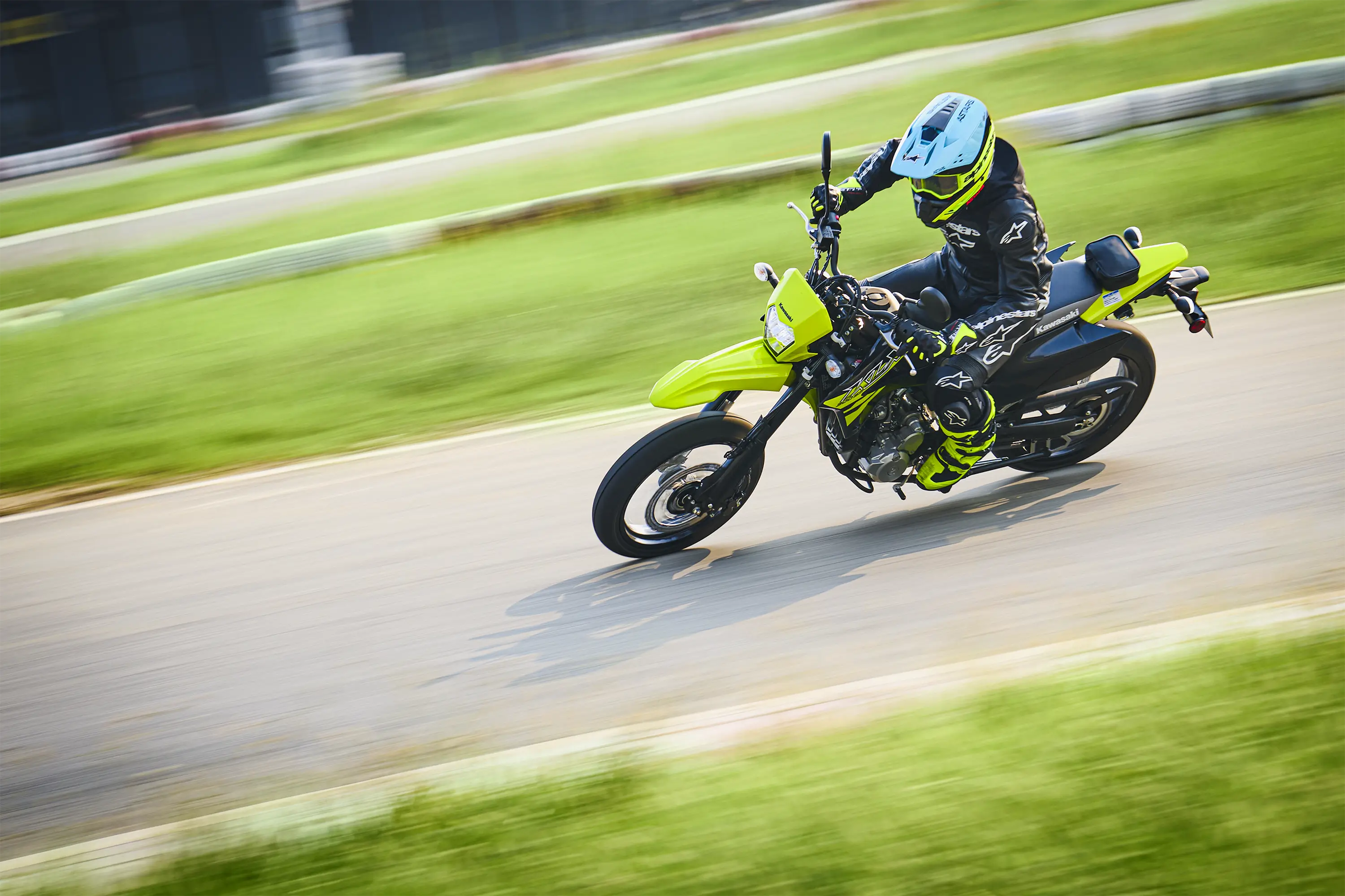 Overhead three-quarter front angle of a person riding a motorcycle on a track.