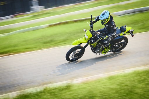 Overhead three-quarter front angle of a person riding a motorcycle on a track. opens in a new window