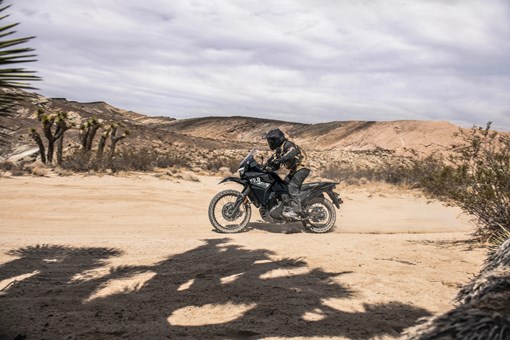 Profile angle of a person riding a motorcycle off-road. opens in a new window